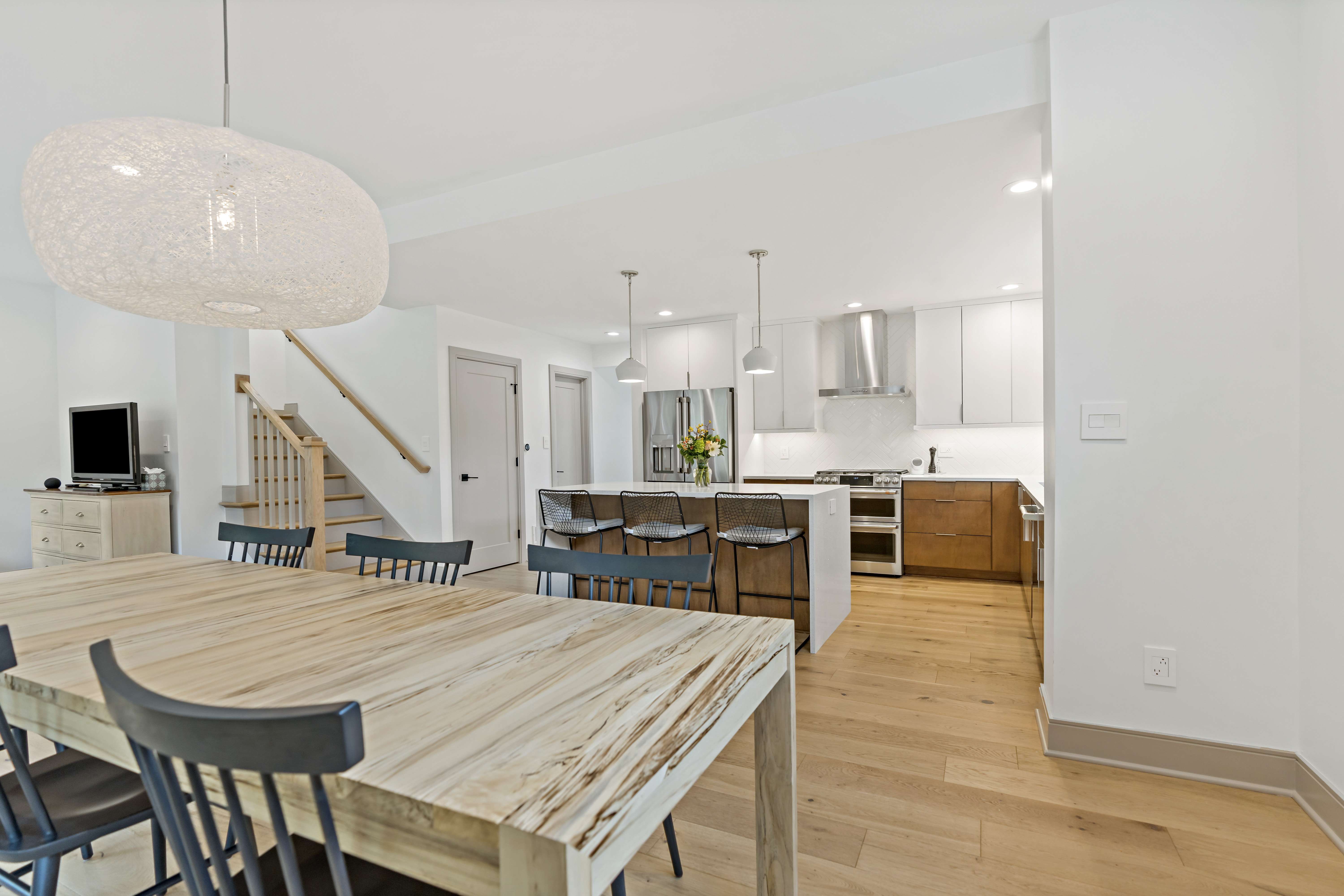 Open kitchen space leading to kitchen table with hard wood floors