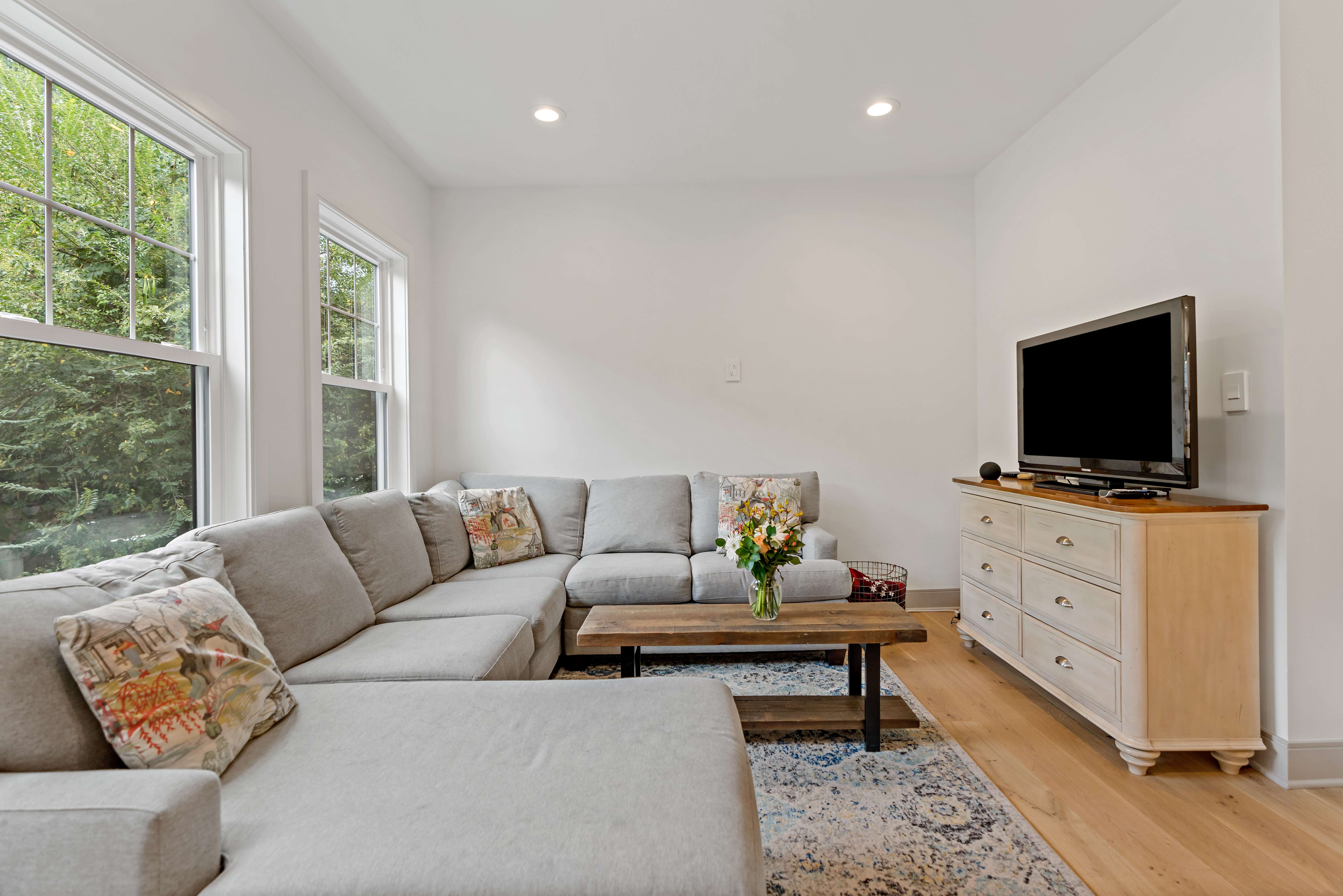 TV room with hardwood floors and two large windows