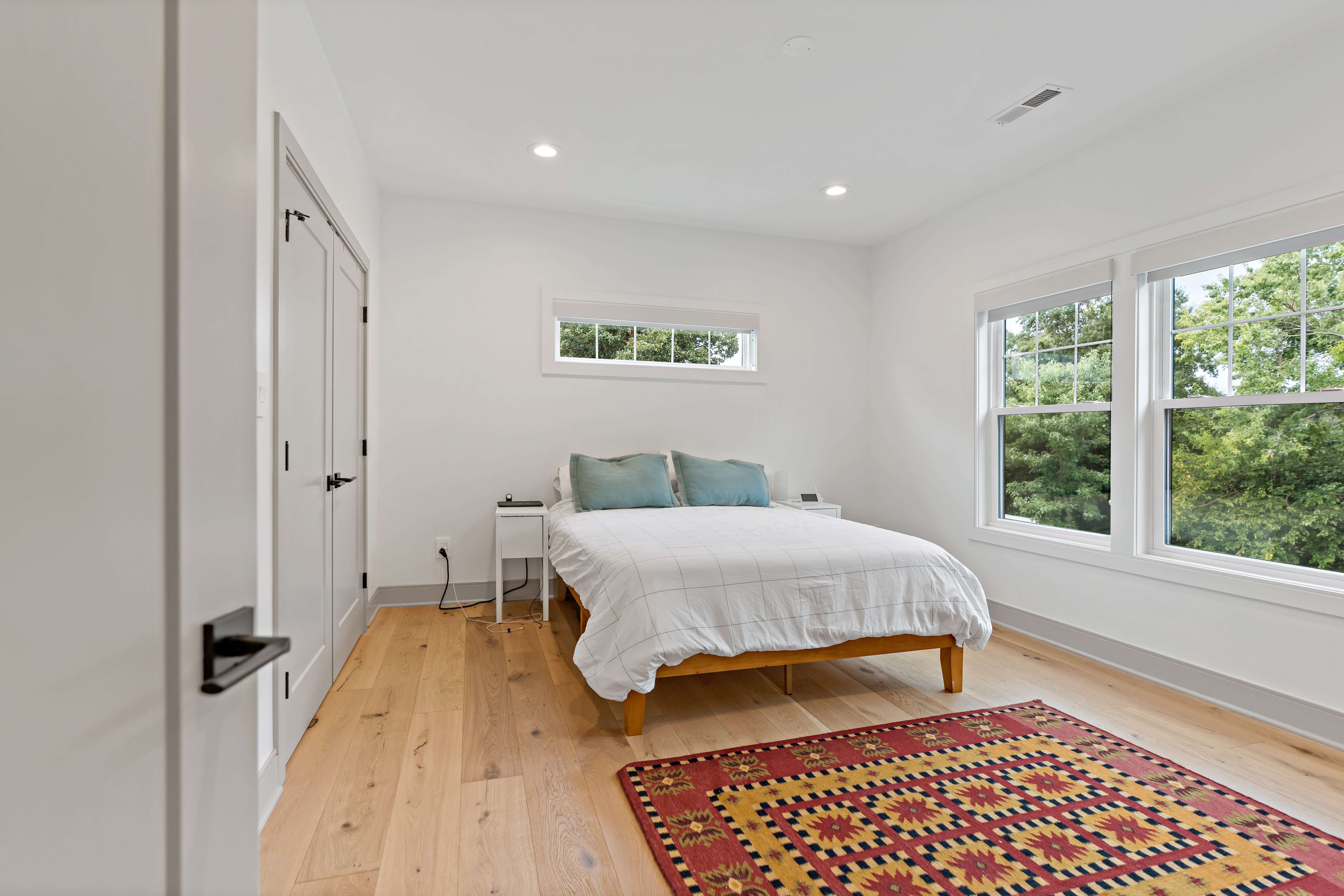 Hardwood floor bedroom with large windows