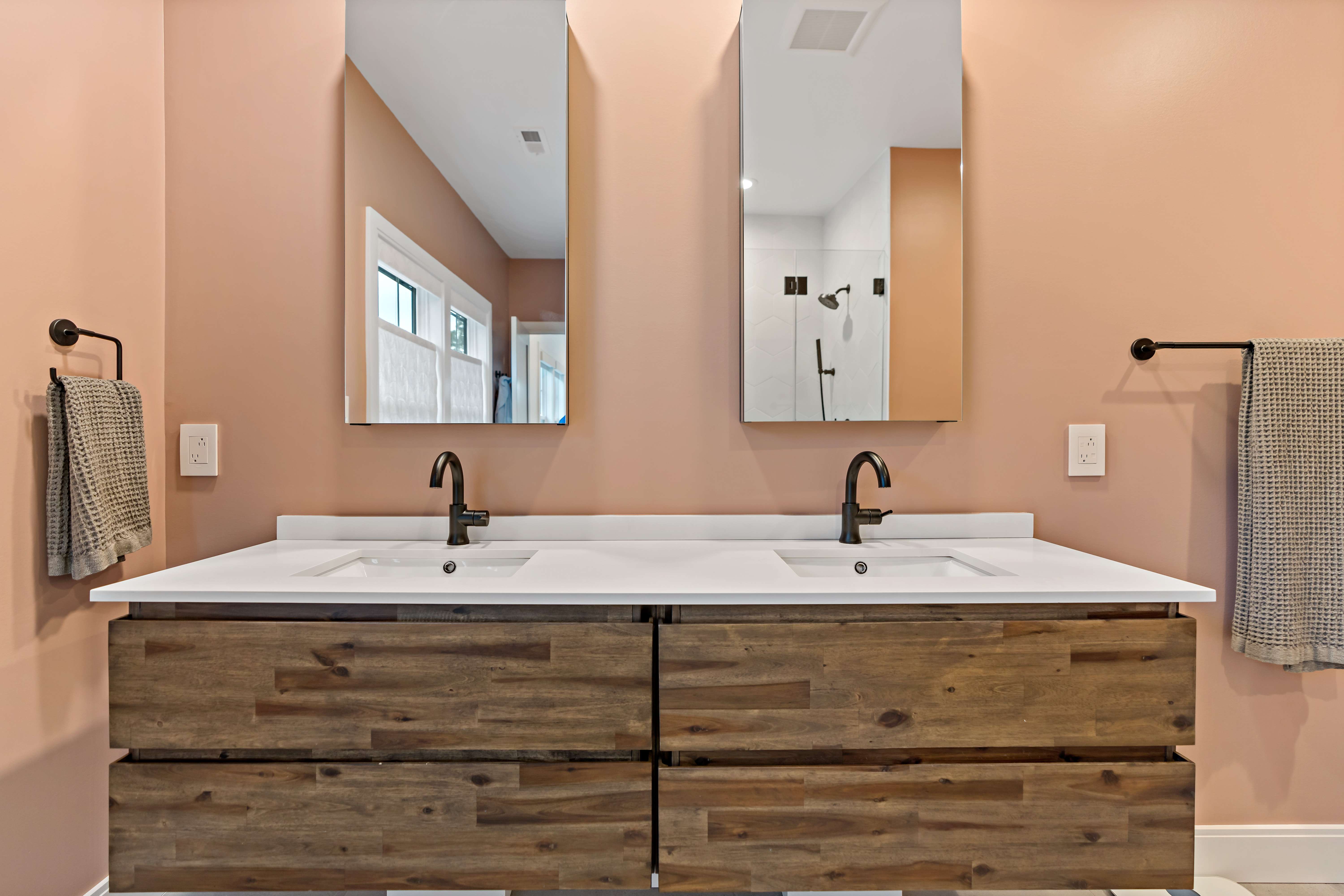 Double vanity bathroom with brown wood cupboards and pink walls