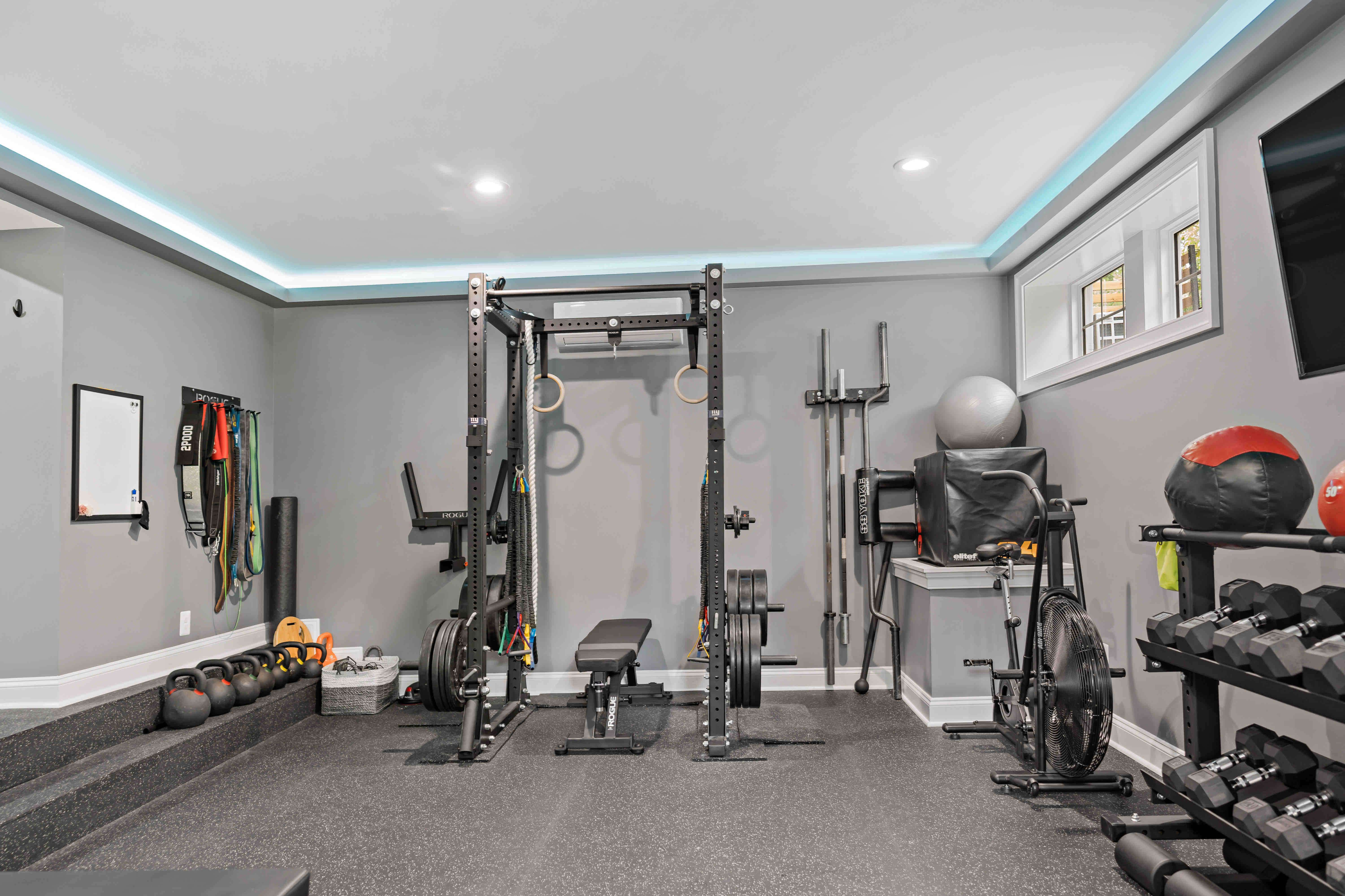 In house gym with blue led lights surrounding the ceiling