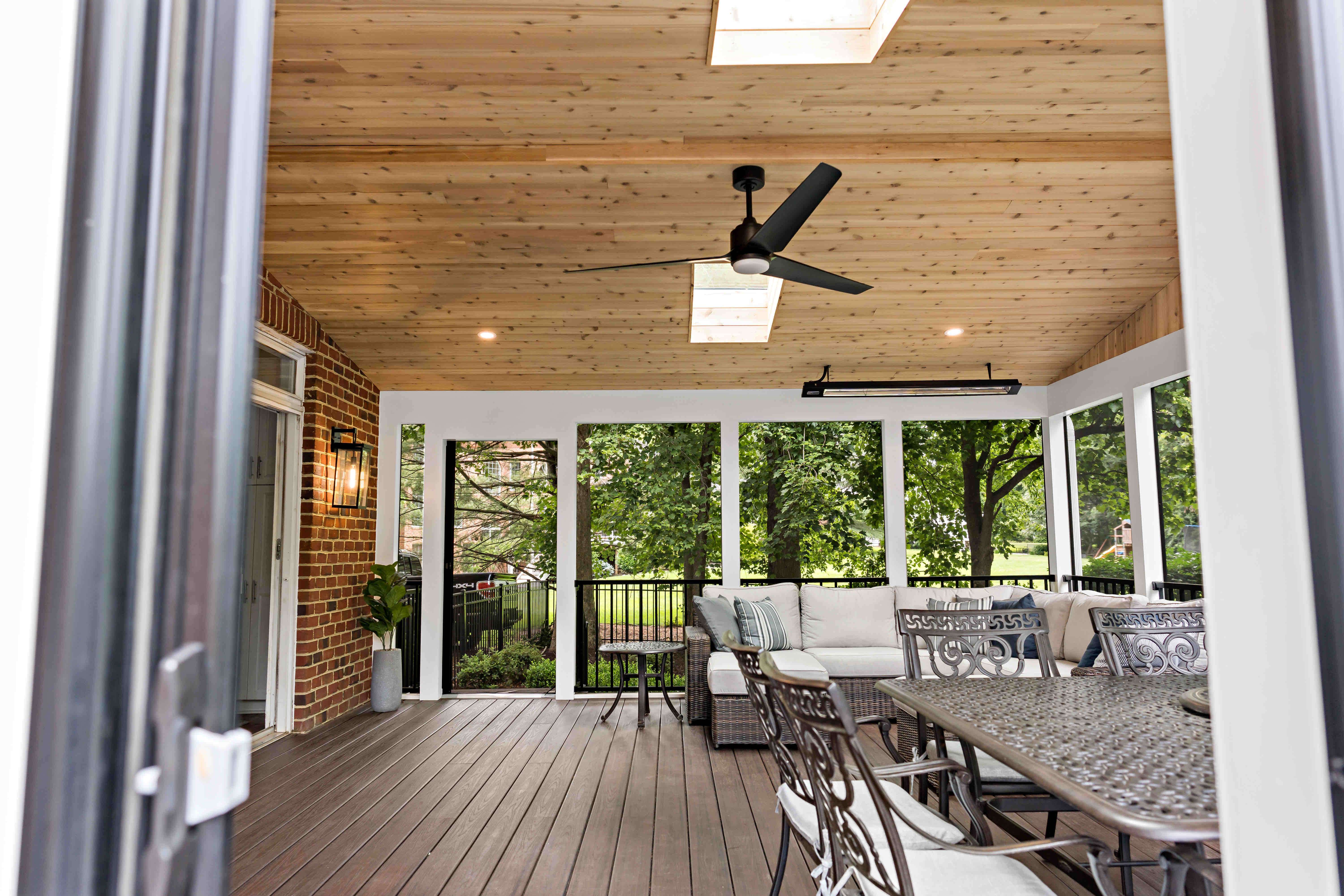 Entrance view of spacious screened porch with a couch and table patio furniture