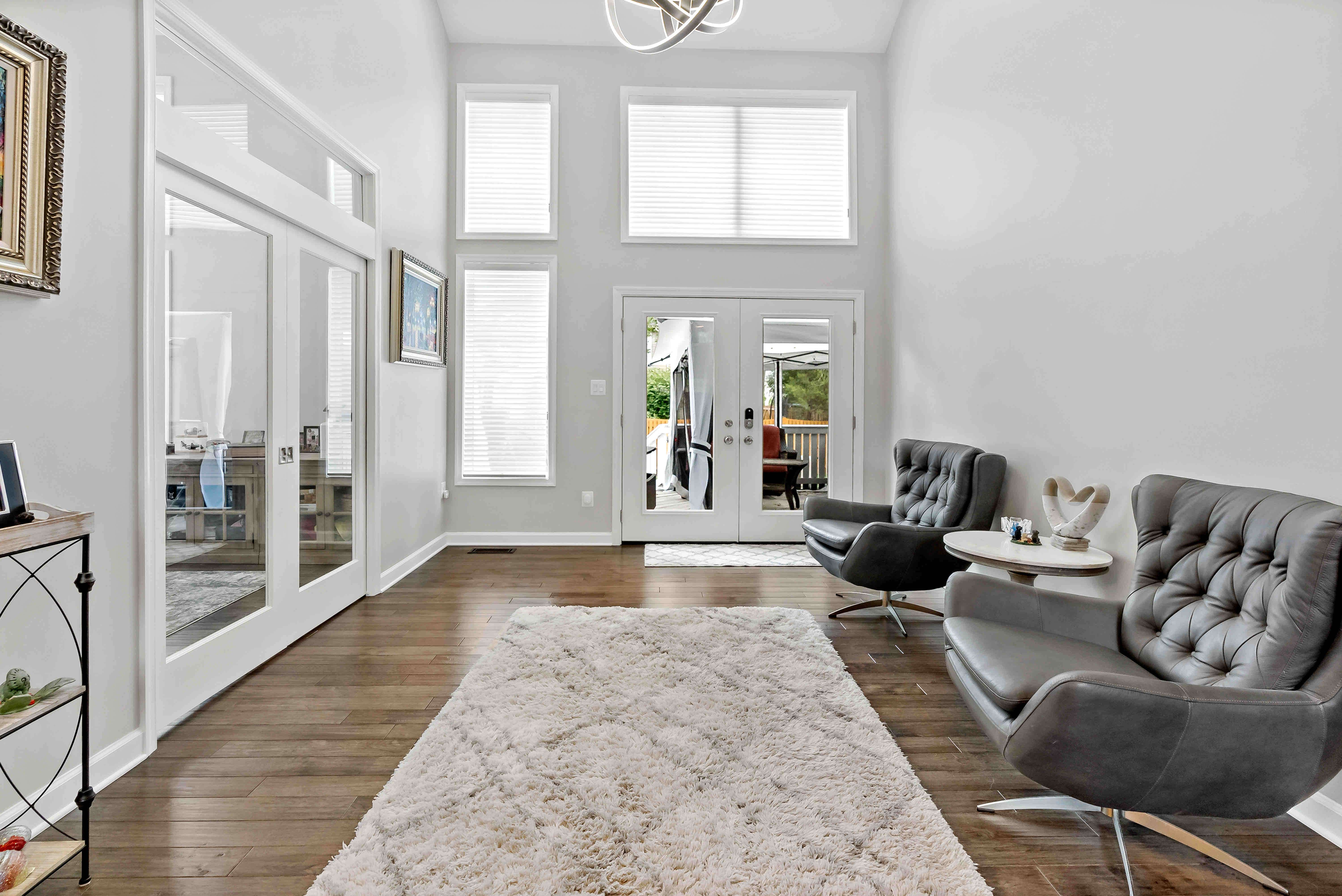 Hard wood floor foyer with black leather chairs