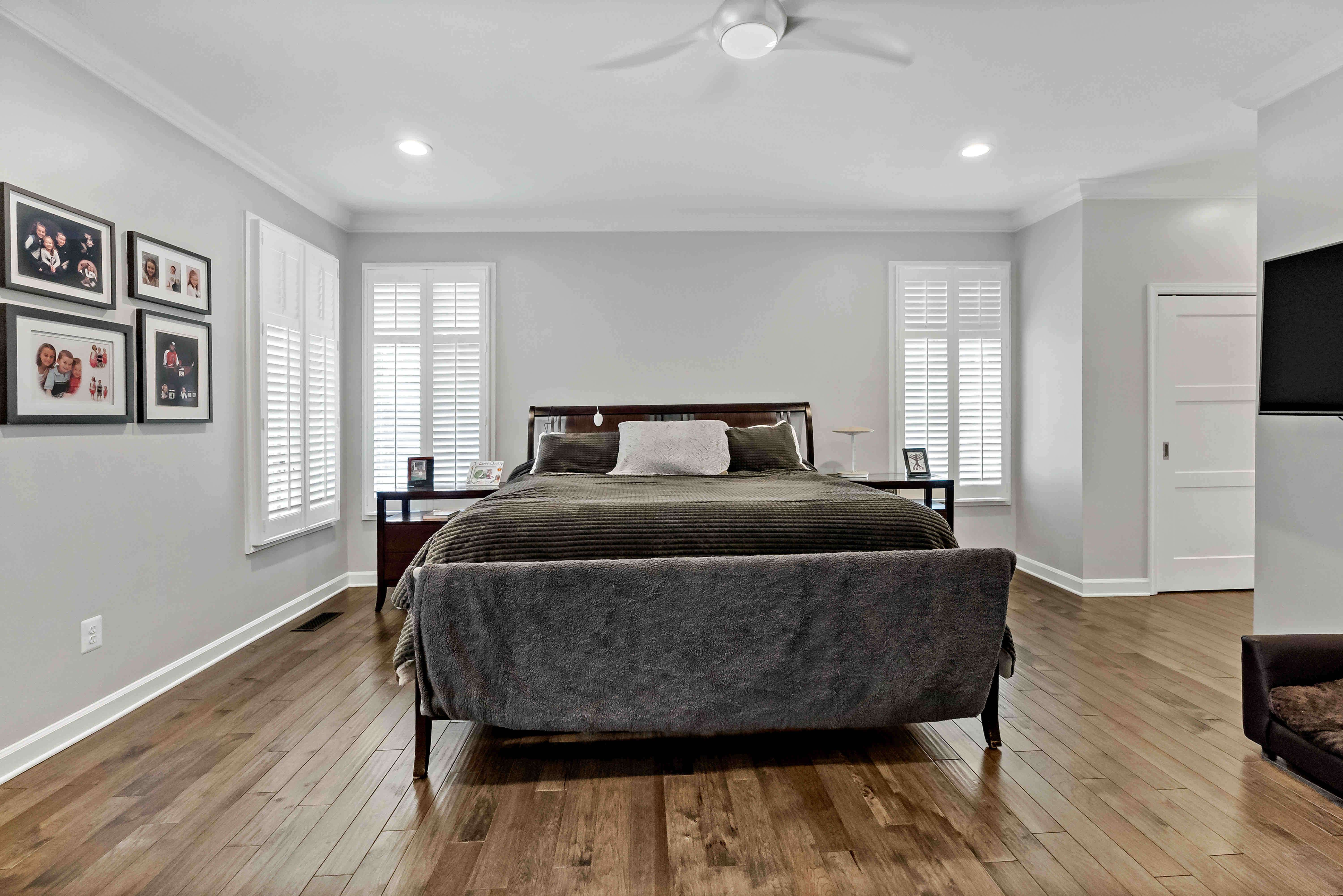 Hardwood floor bedroom with white walls and trim