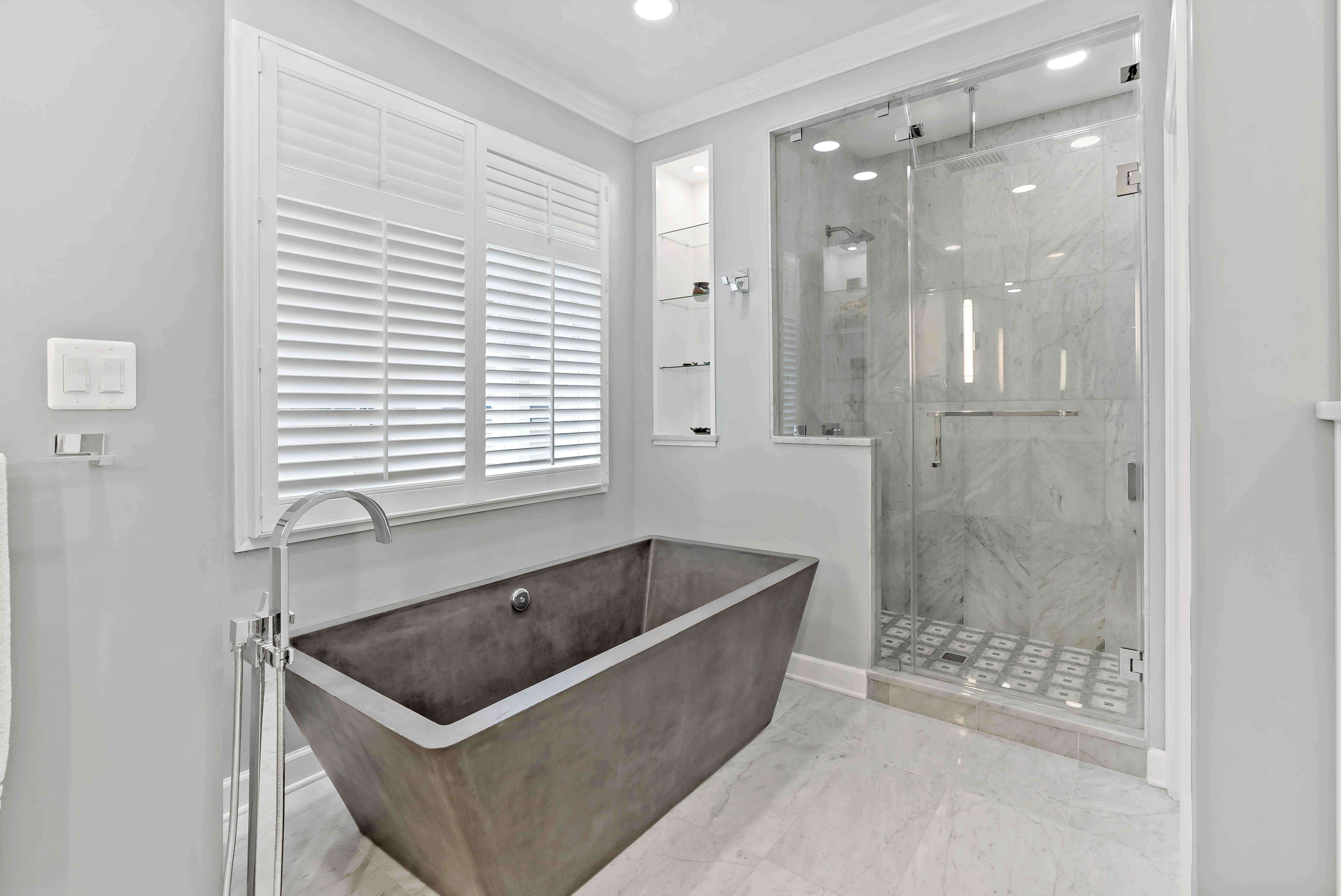 Rectangular stand-alone bathtub and glass shower door