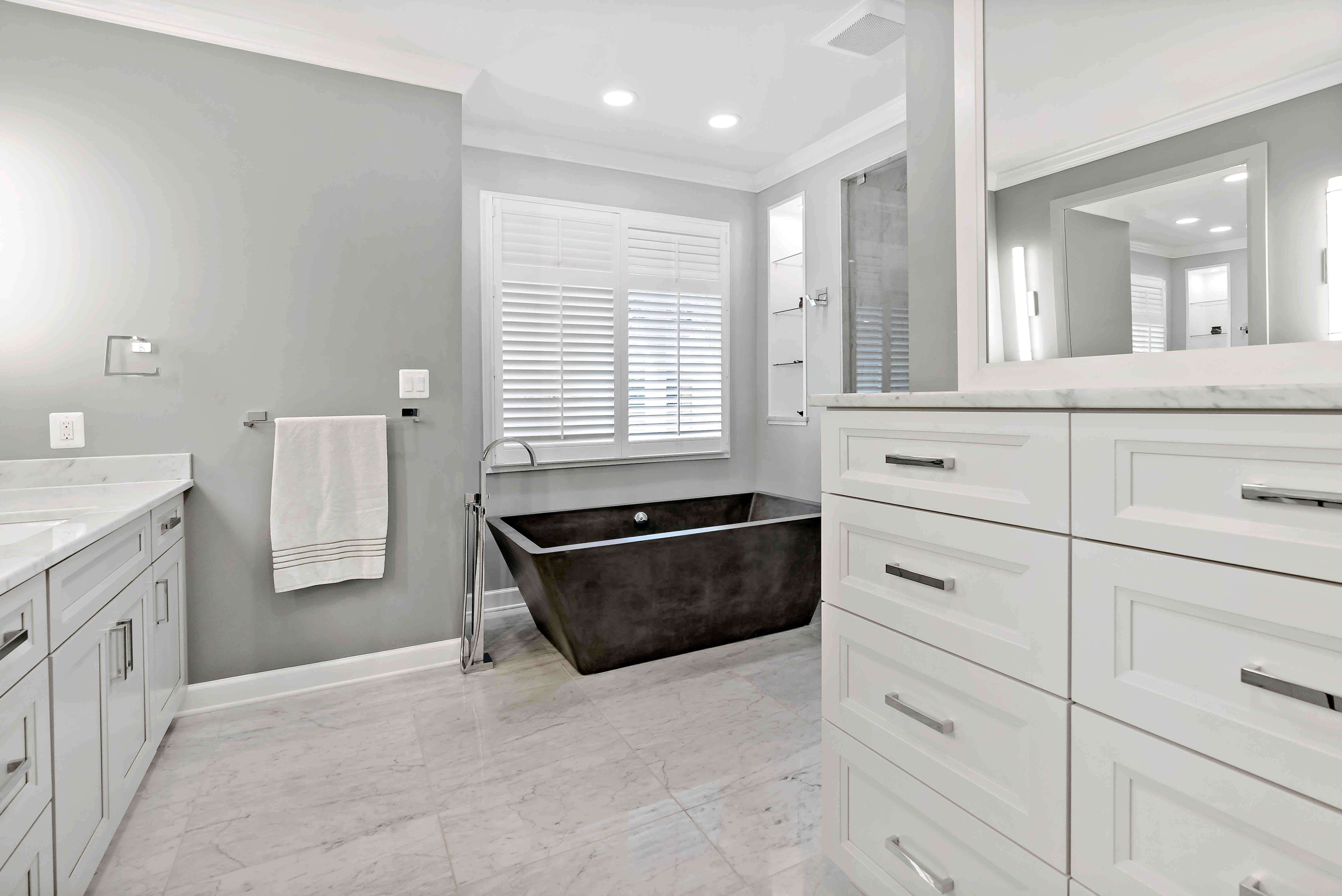 Large full bathroom with white cabinets