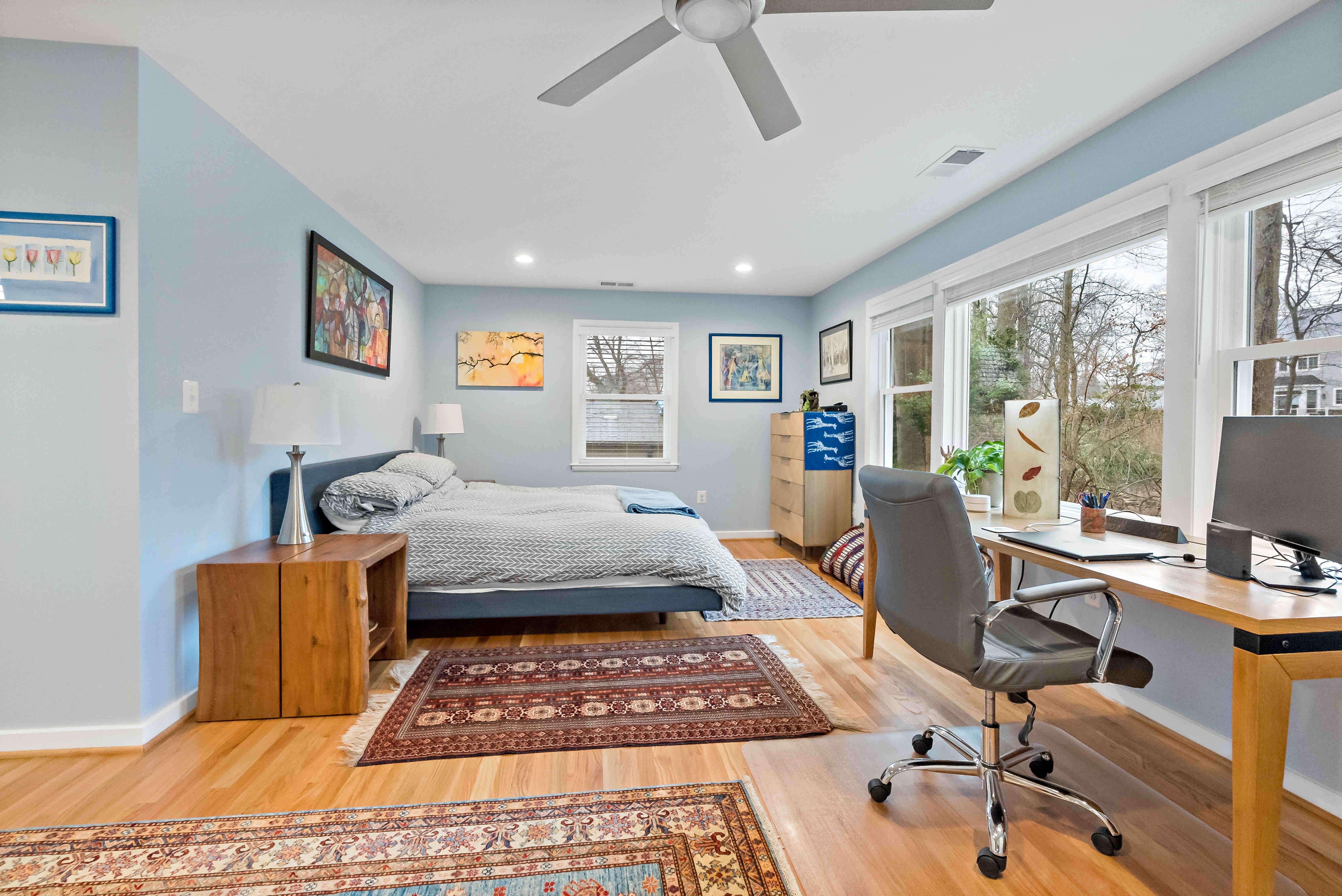 Hardwood floor bedroom with light blue walls and ceiling fan