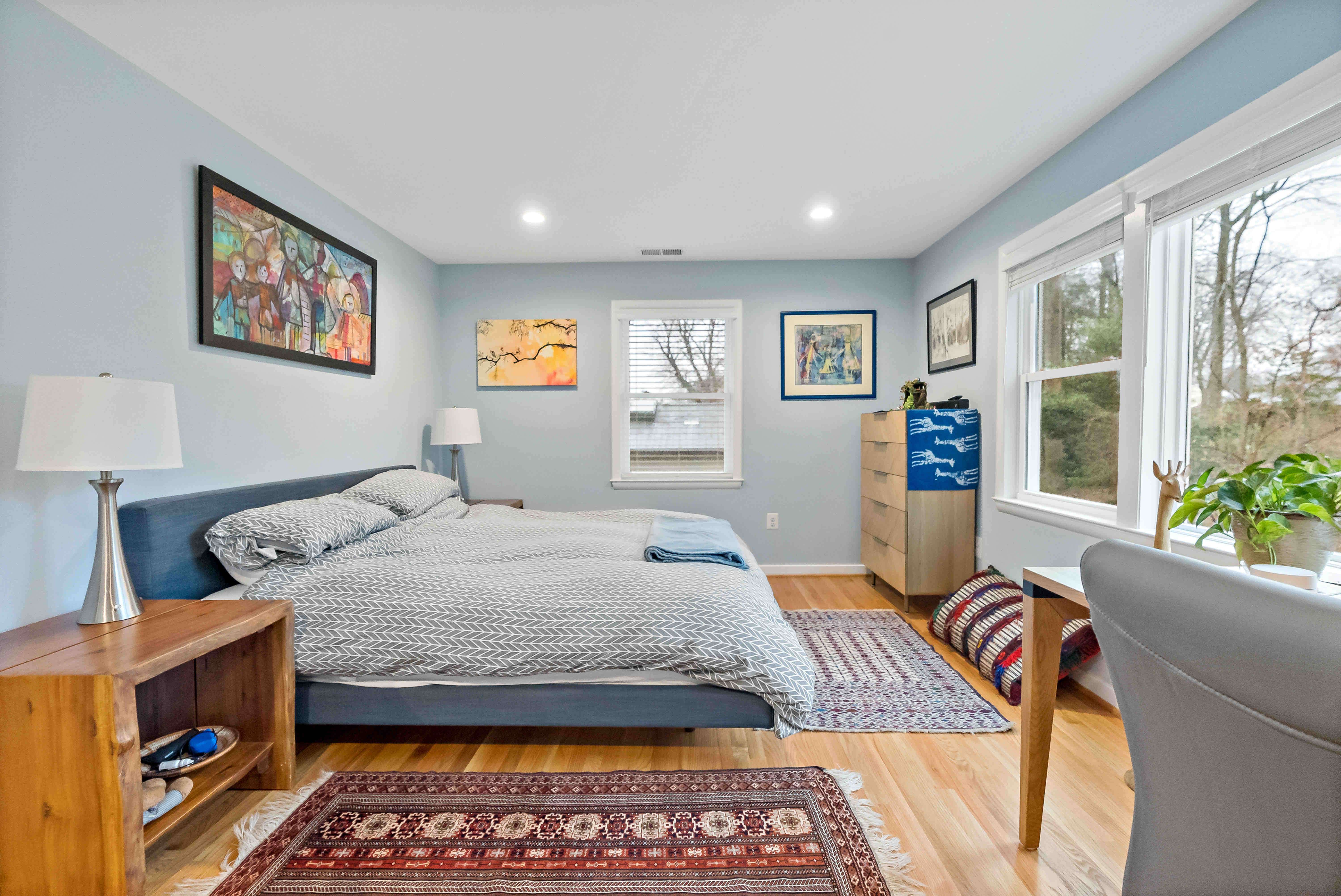 Light blue walls in bedroom with bed facing large window to enjoy scenic backyard