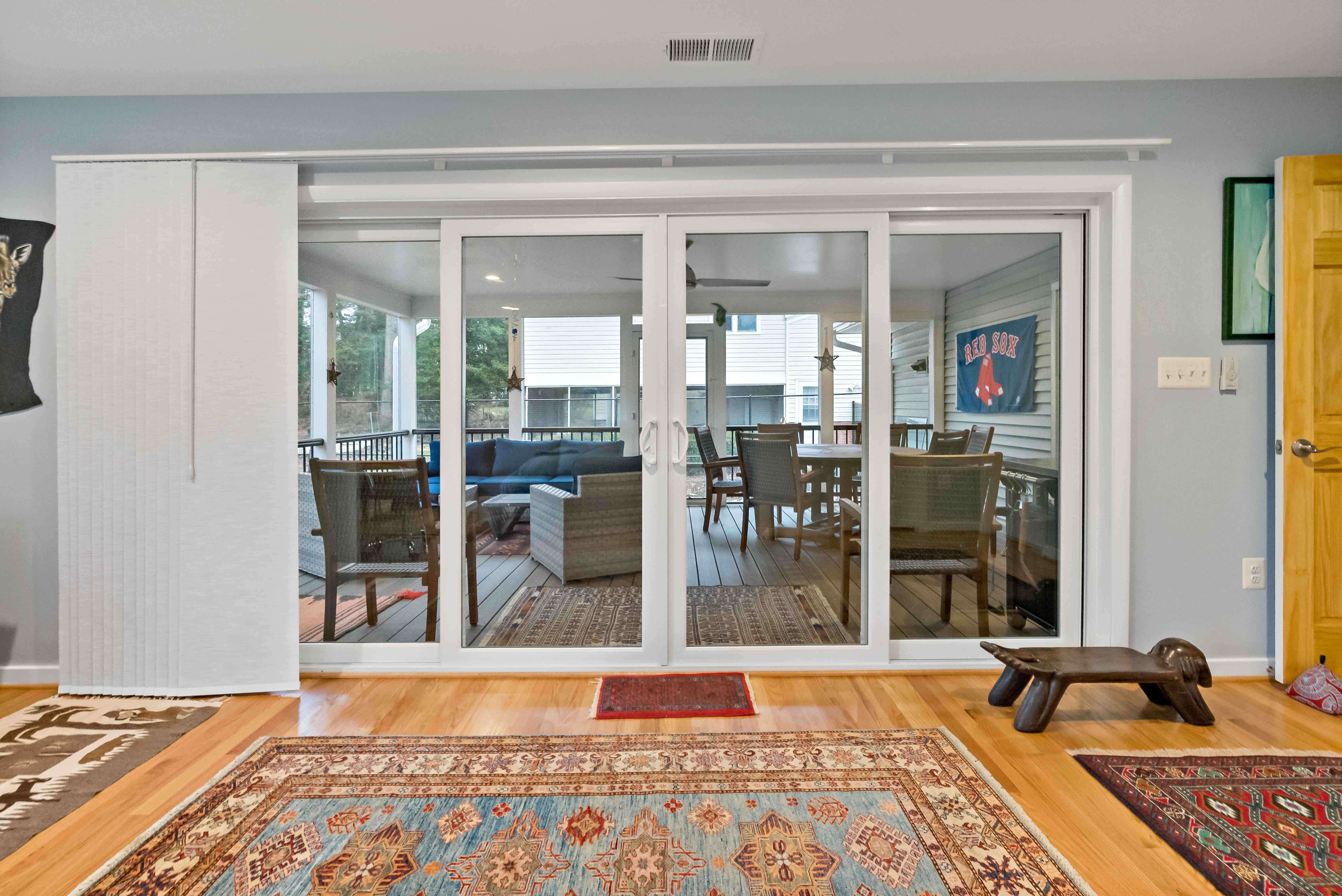 Large double sliding door with blinds leading to screened porch