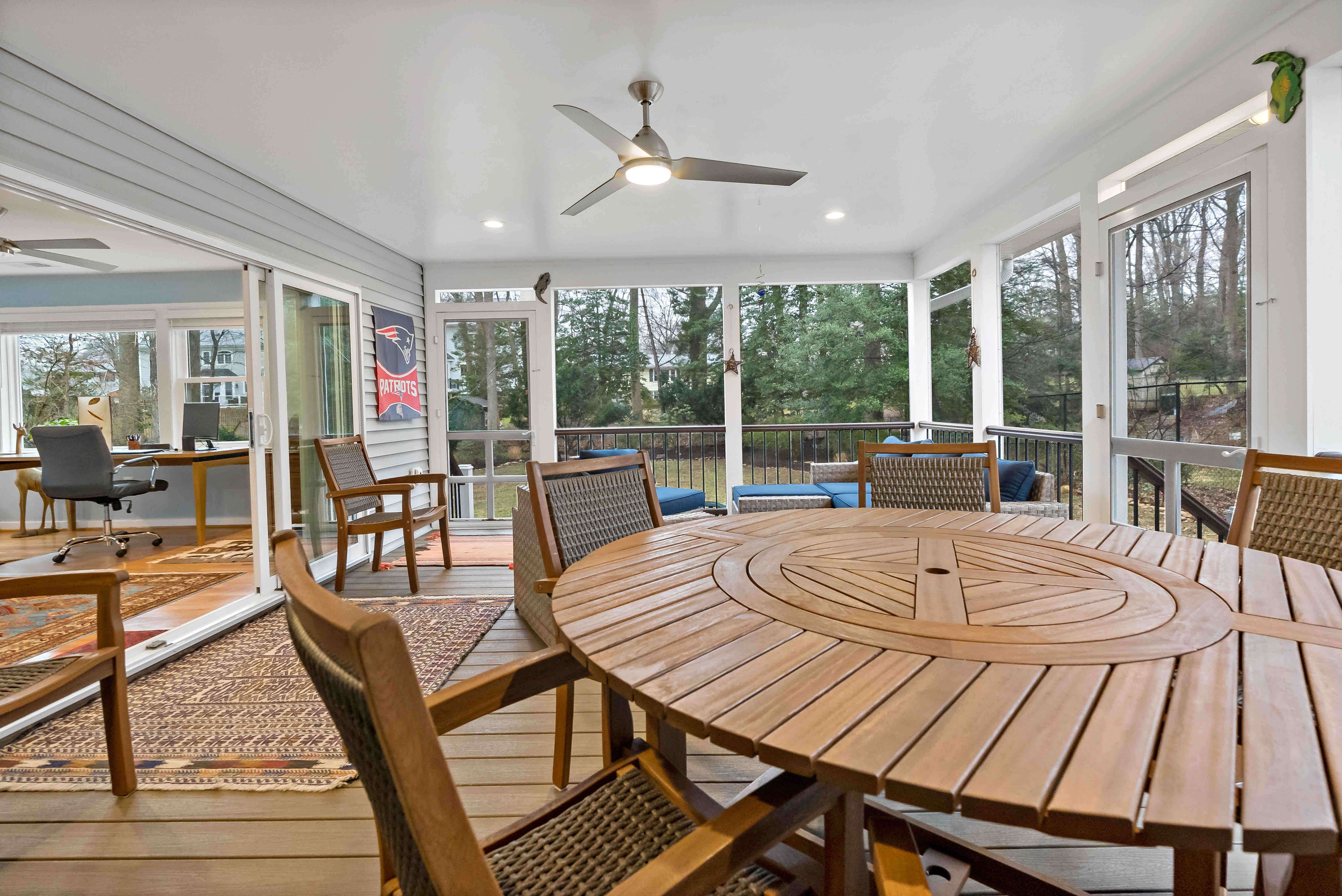 Open and spacious screened porch with wooden patio furniture