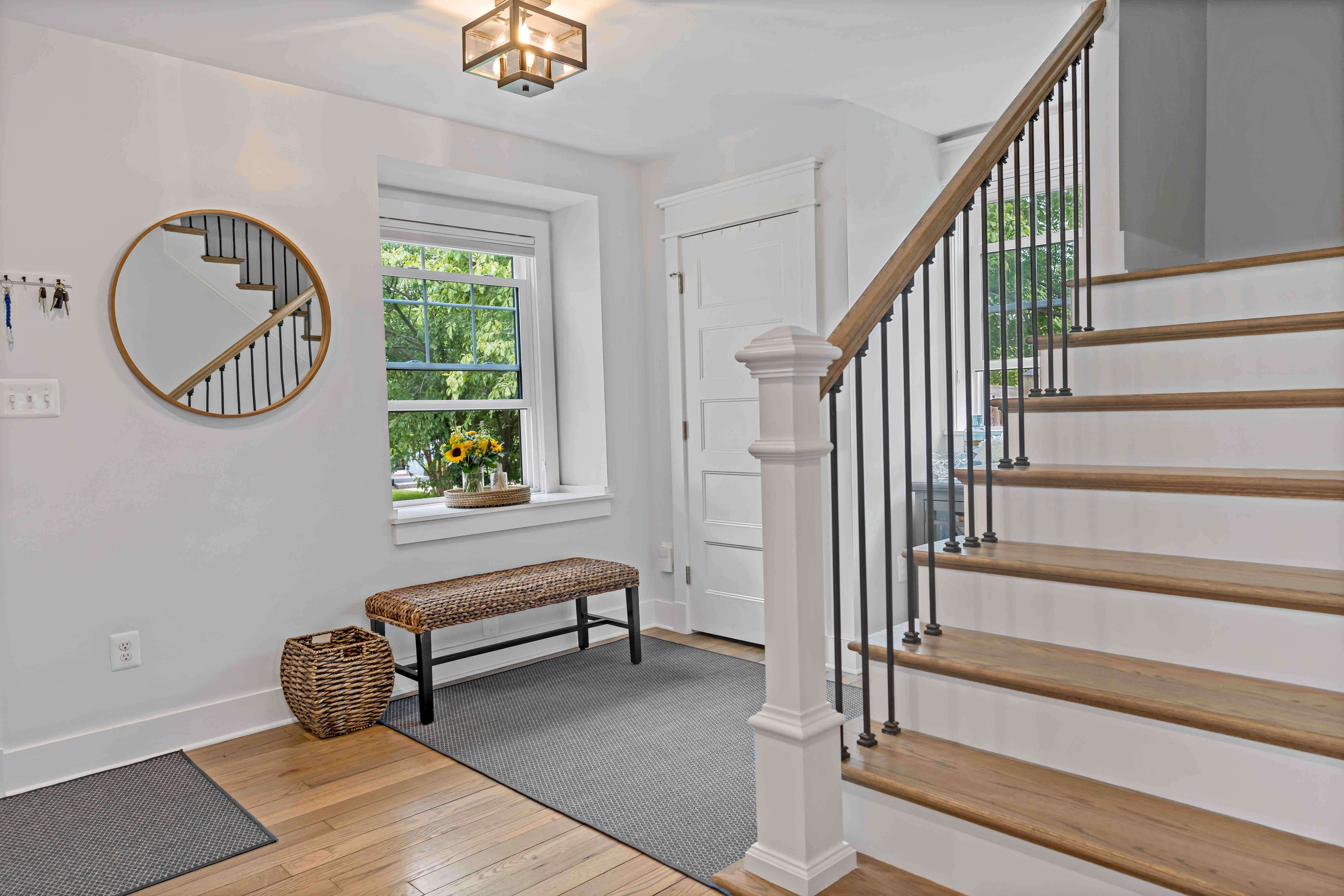 Hardwood floors foyer with white walls and wood staircase leading upstairs