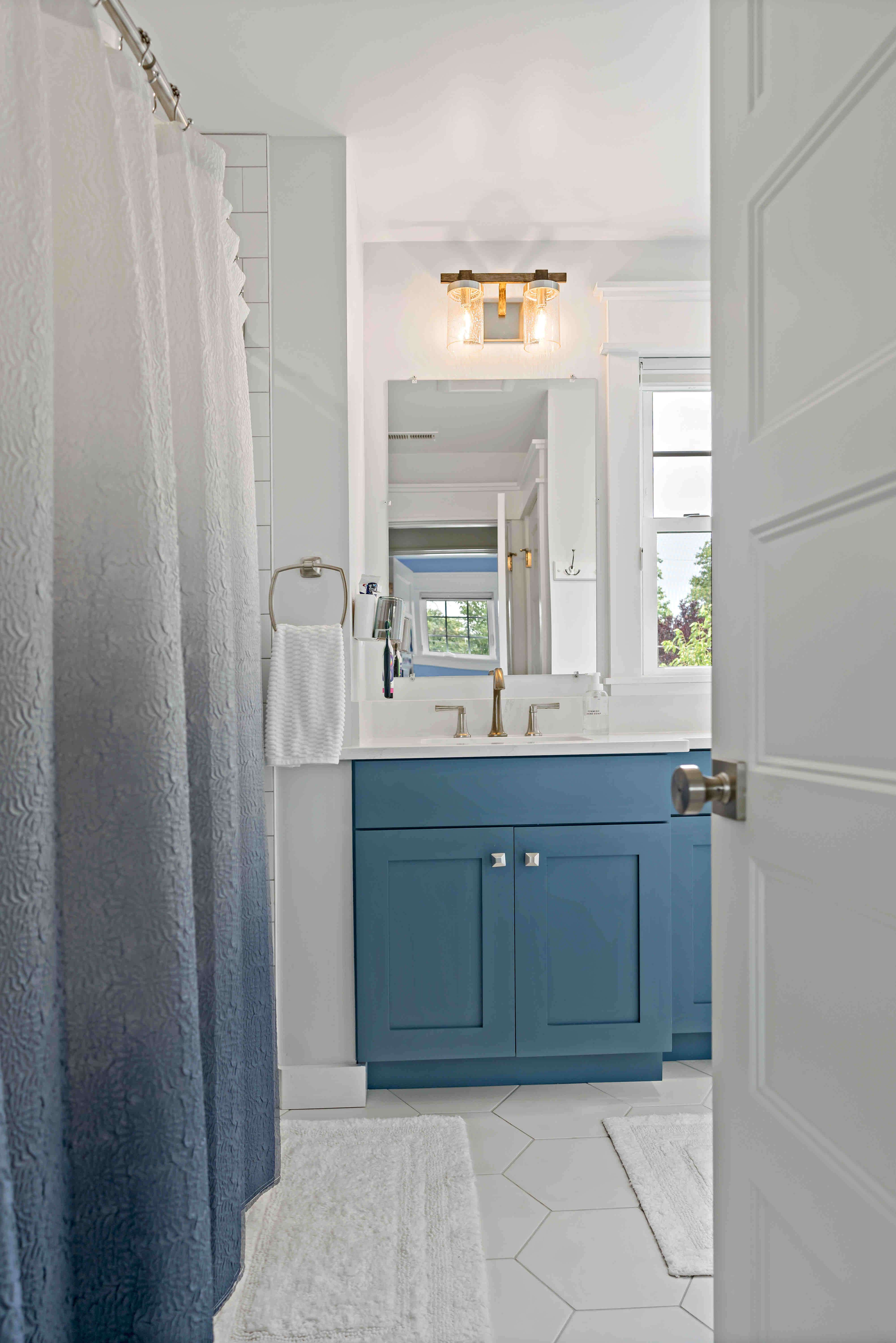 White bathroom with blue cabinets and vanity