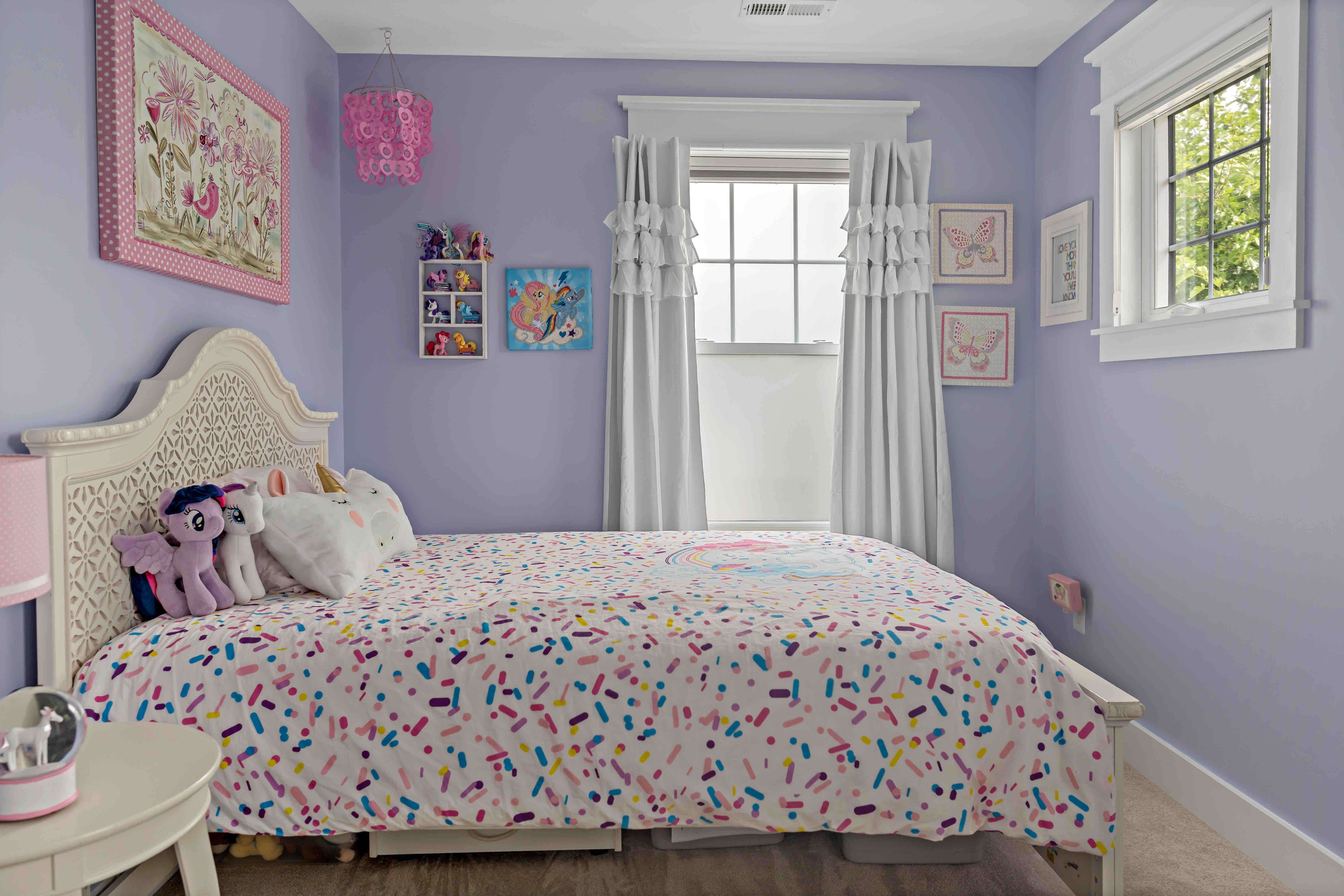 Girls bedroom with purple walls and white curtains