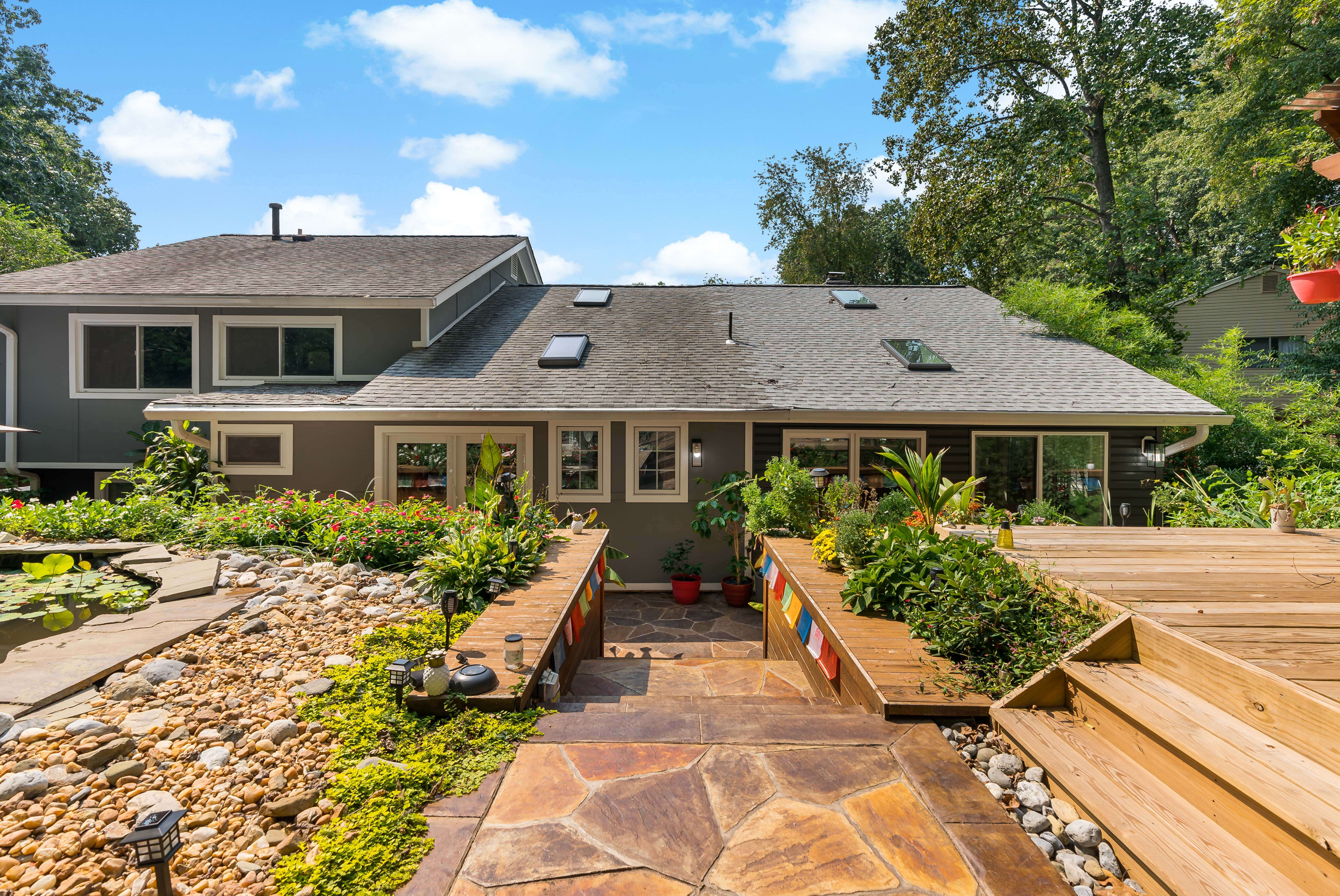 Back of home with stone walkway to home