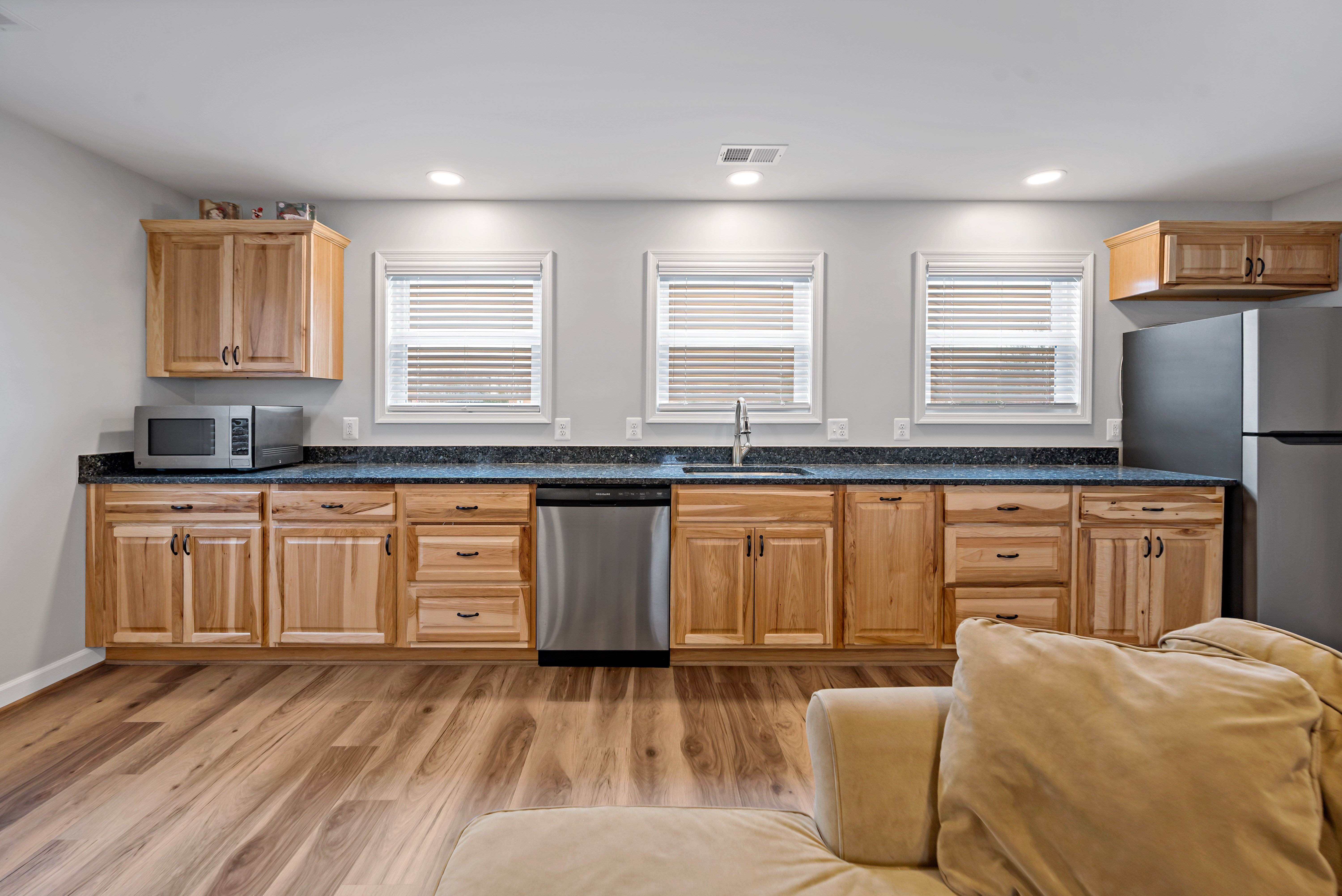 Second kitchen area with brown cabinets and wood floors