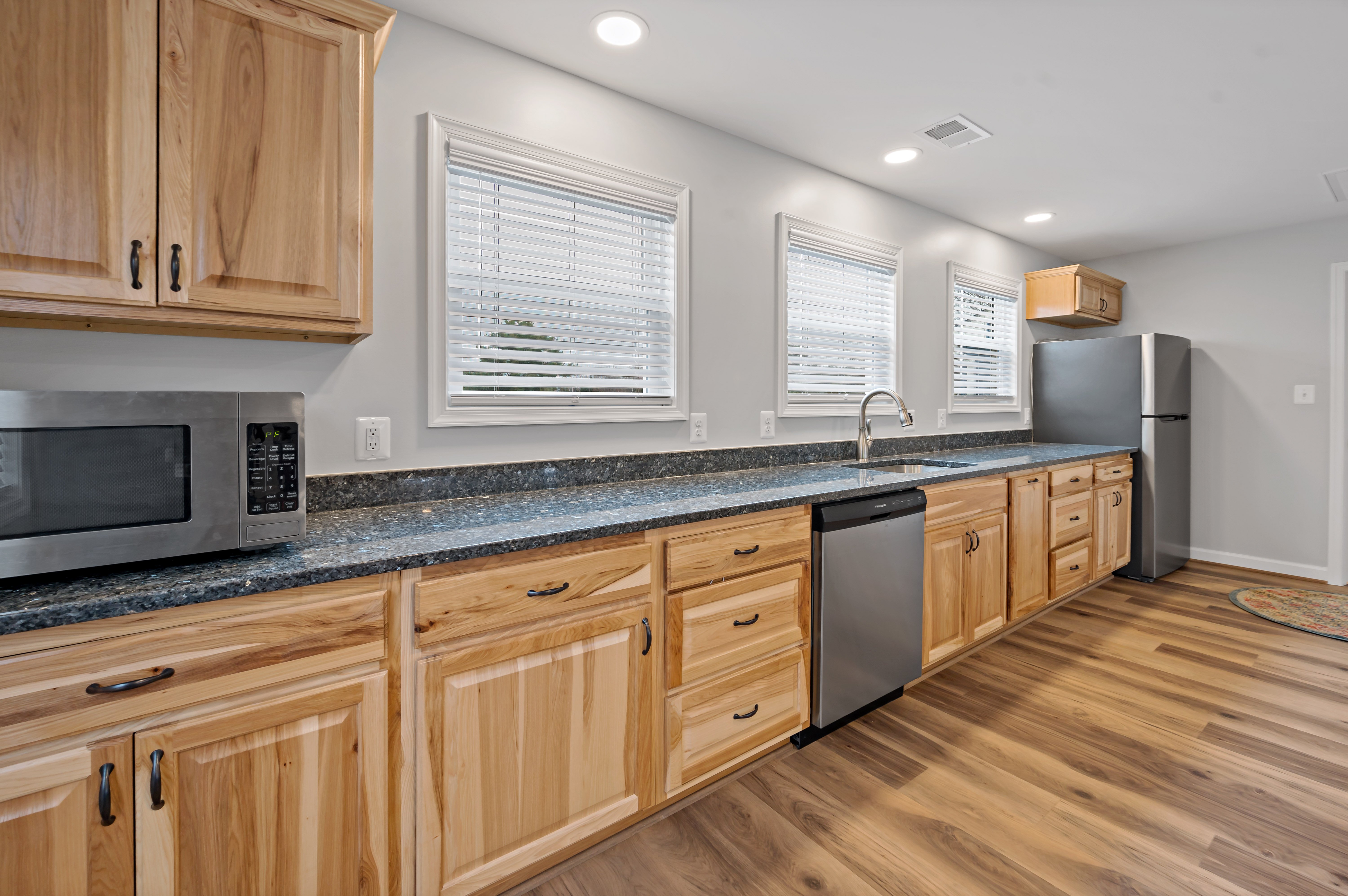 Brown wood cabinets with dark green countertops