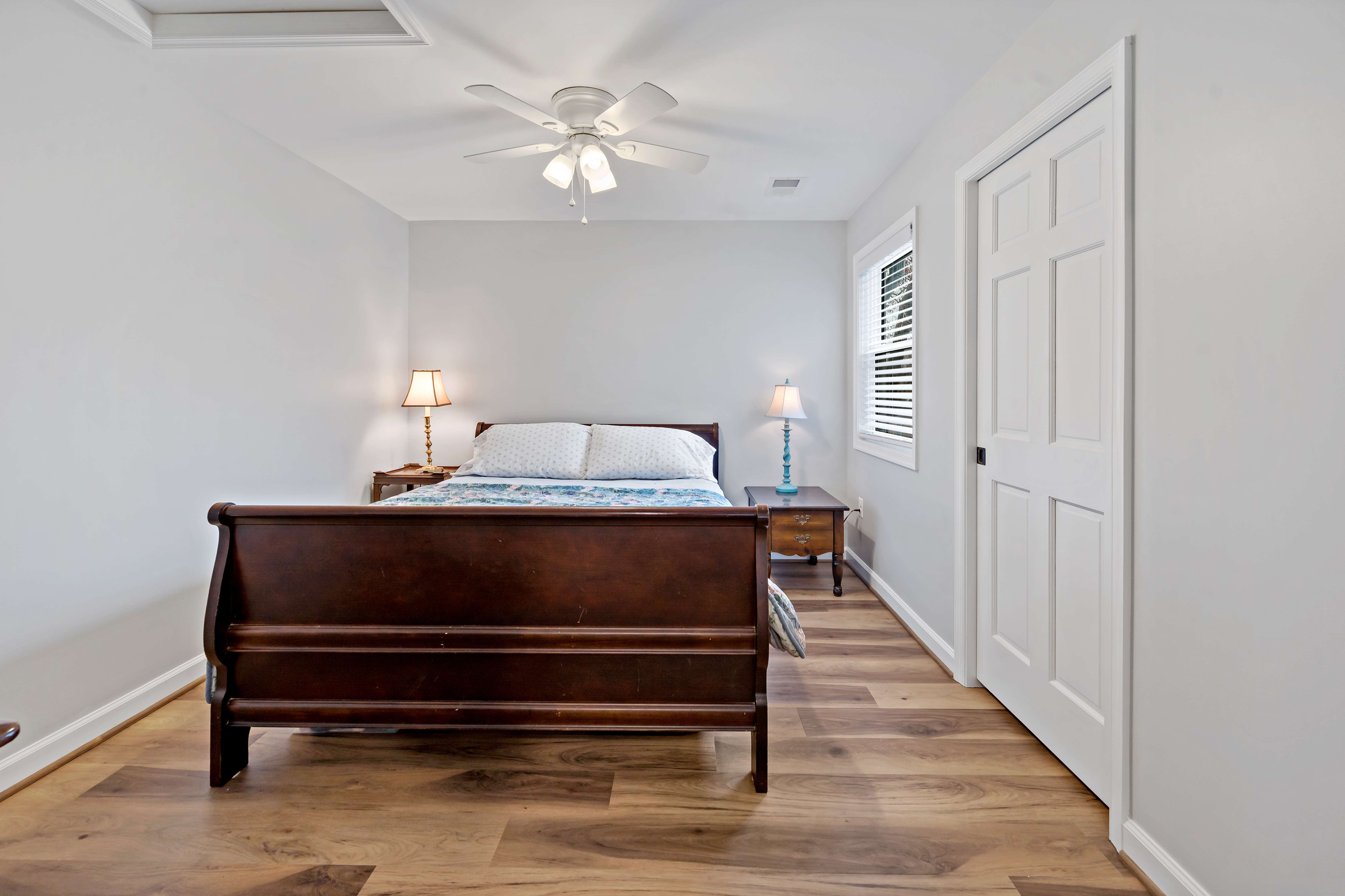 Small bedroom with hardwood floors and white ceiling fan