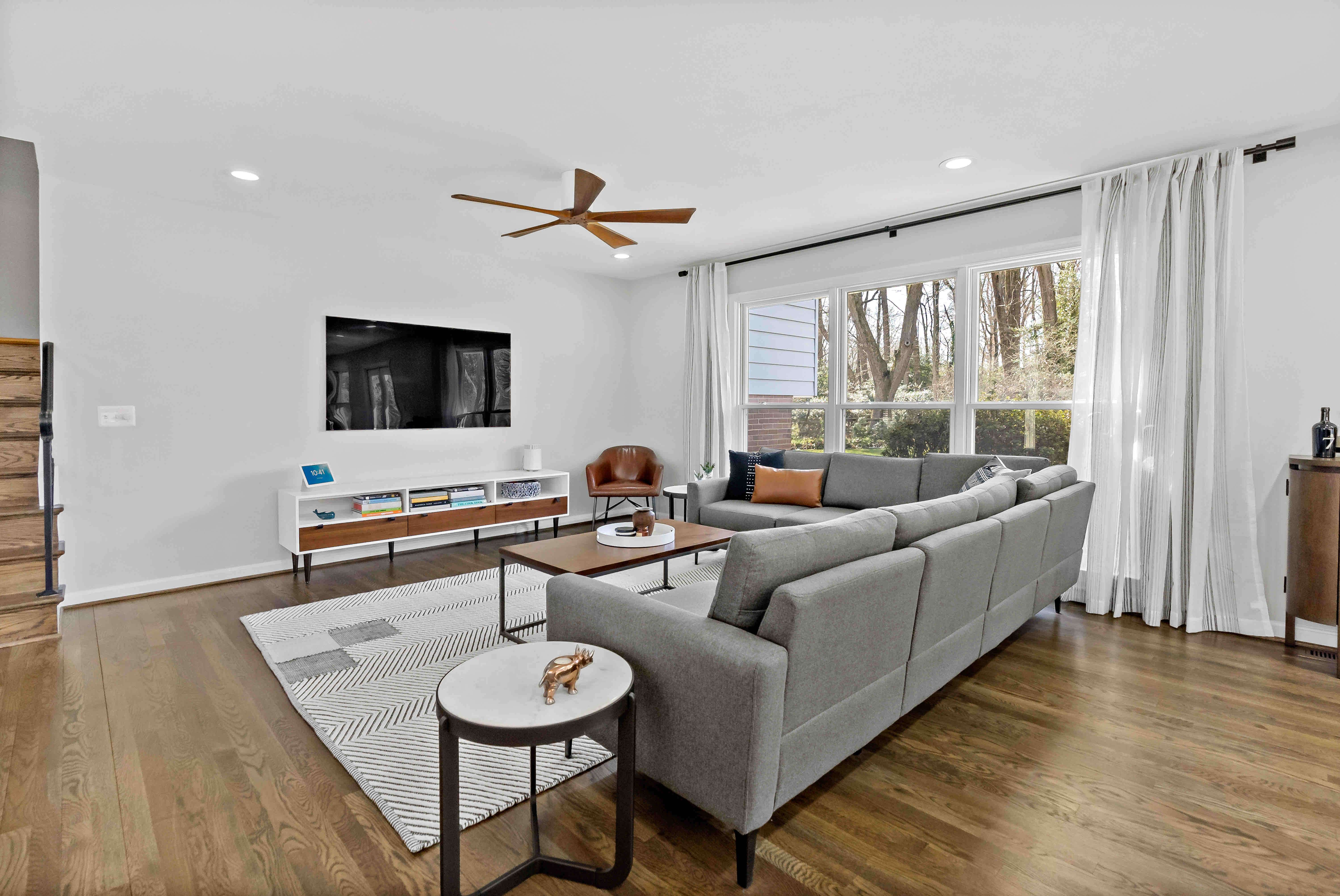 Long white curtains and hard wood floors in living room