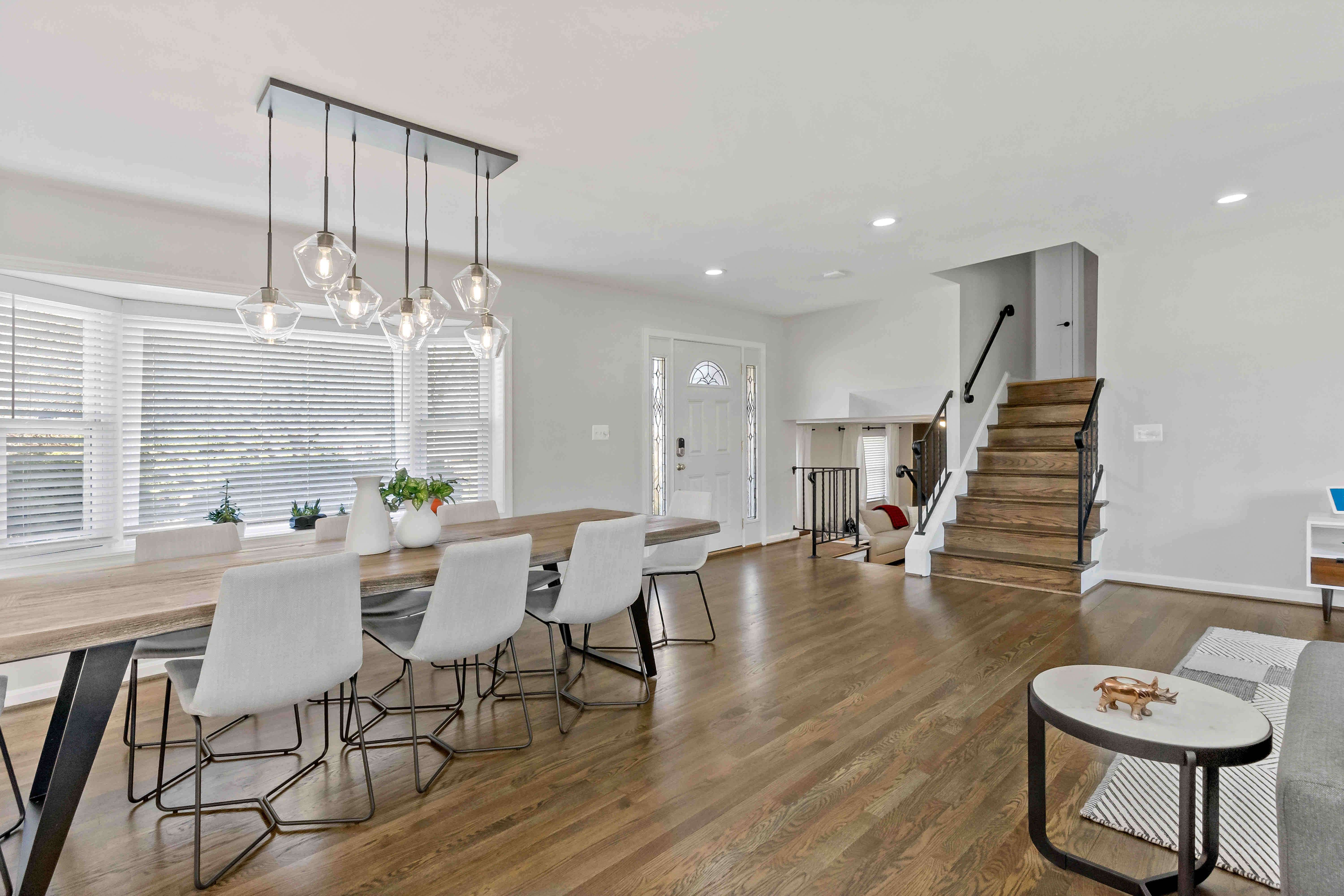 Staircase in open area with kitchen and dining table leading upstairs