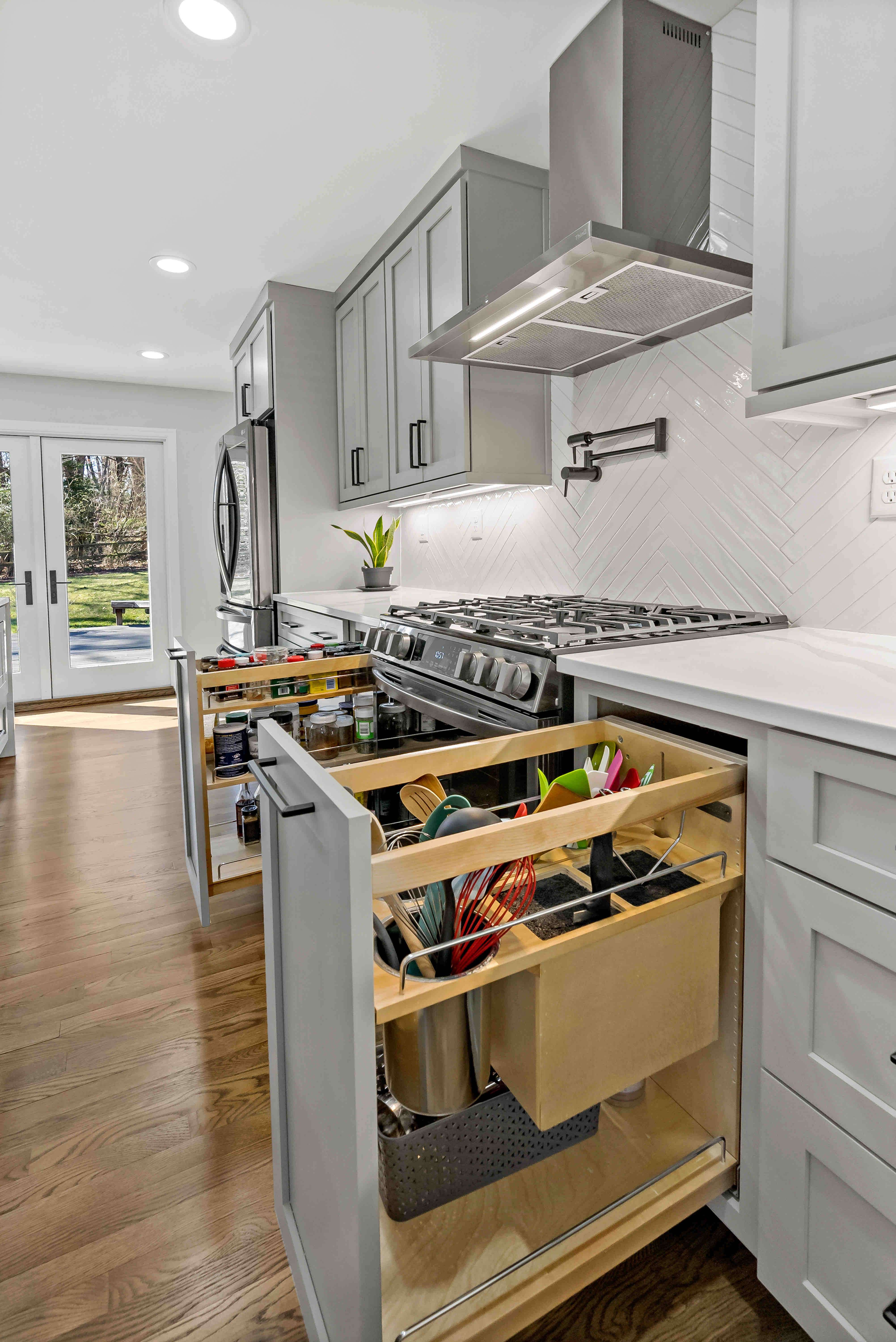 Custom cabinetry pull-out drawers in kitchen by stove