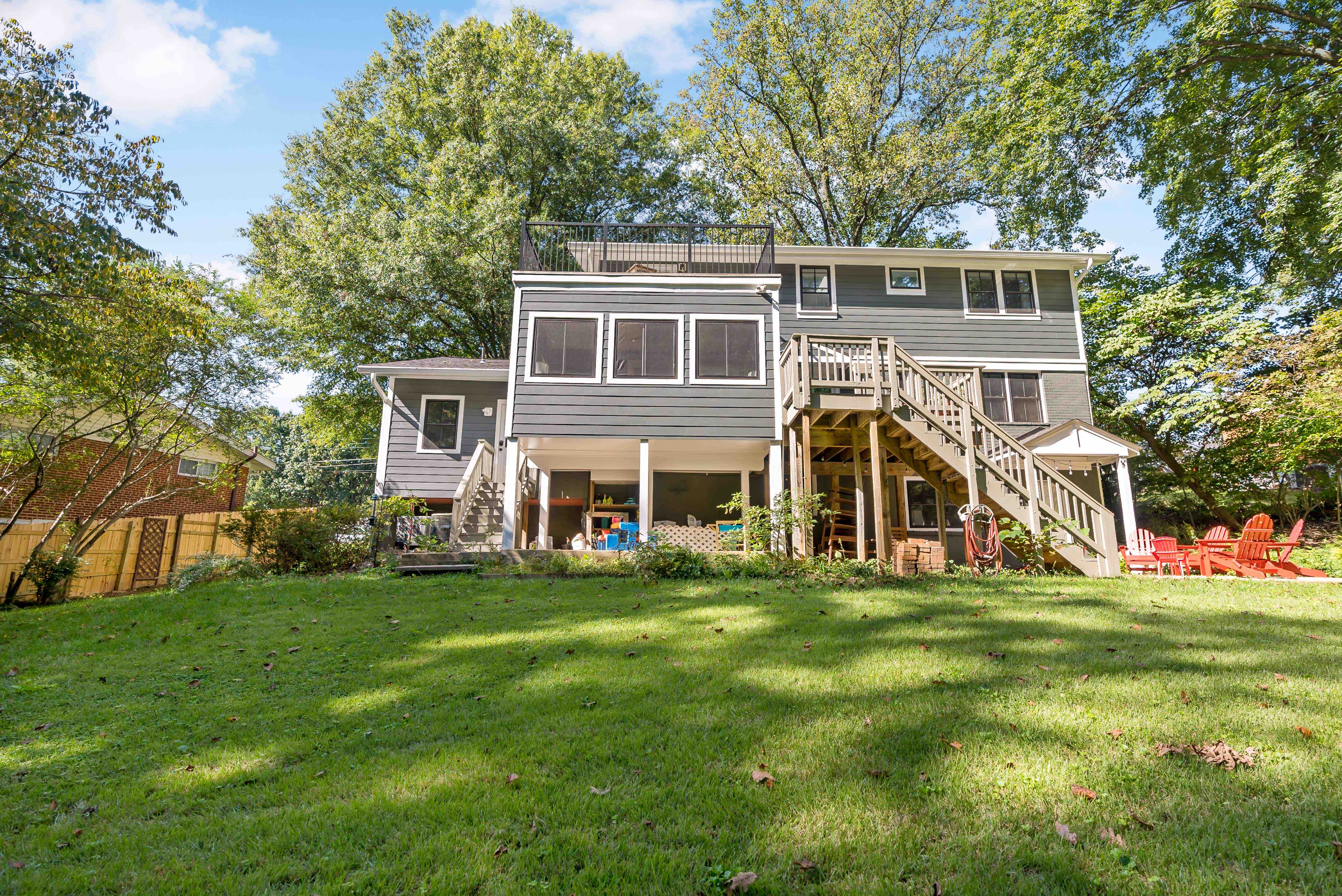 Backyard view of house with raised sunroom