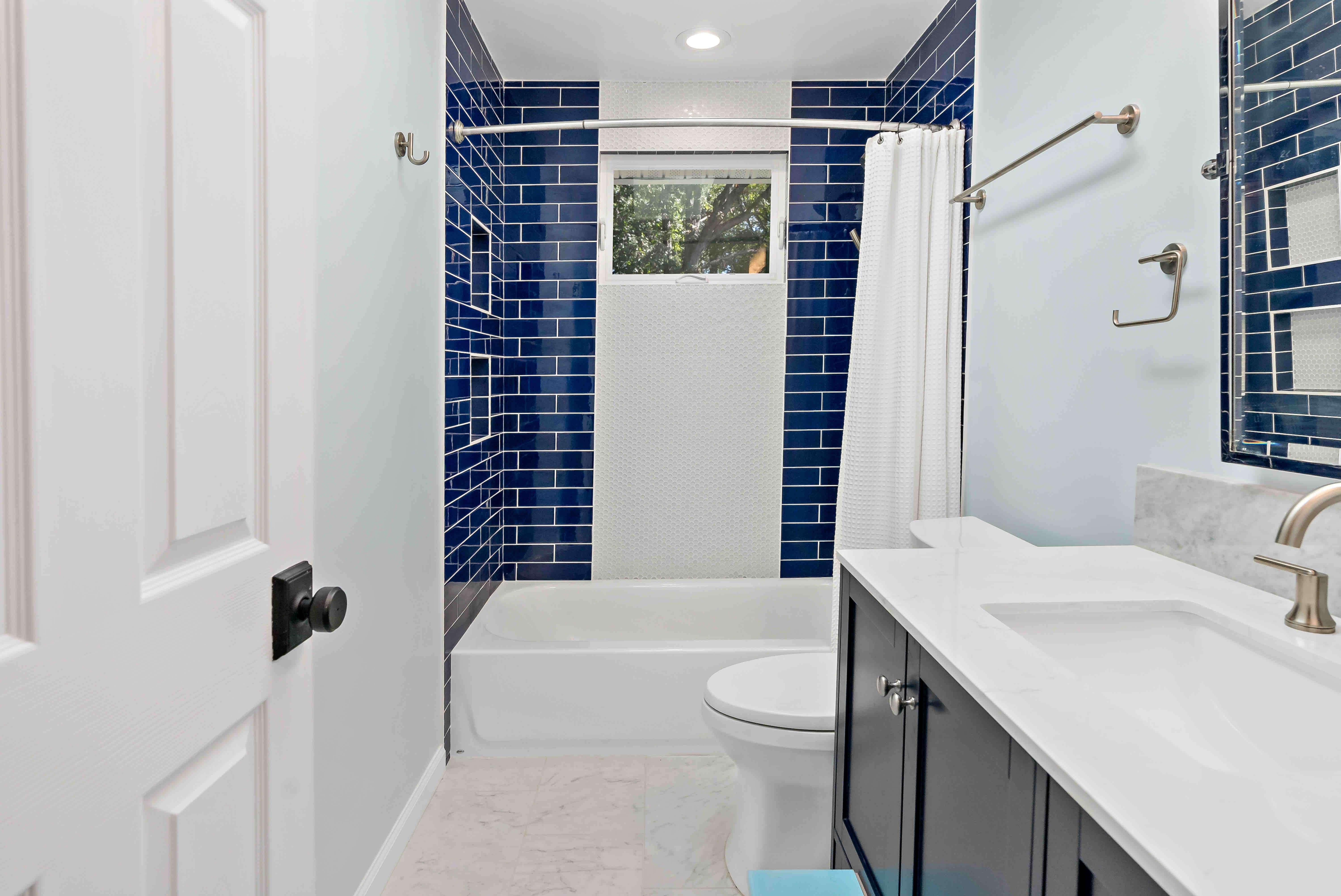 White bathroom with dark blue shower tile