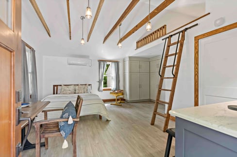 Cathedral ceiling with exposed wood beams in bedroom area of garage suite