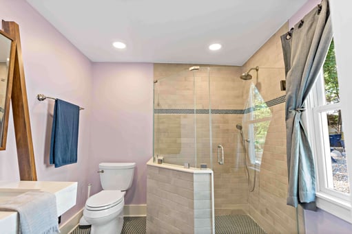 Full bathroom with walk-in shower with glass walls and pink painted walls