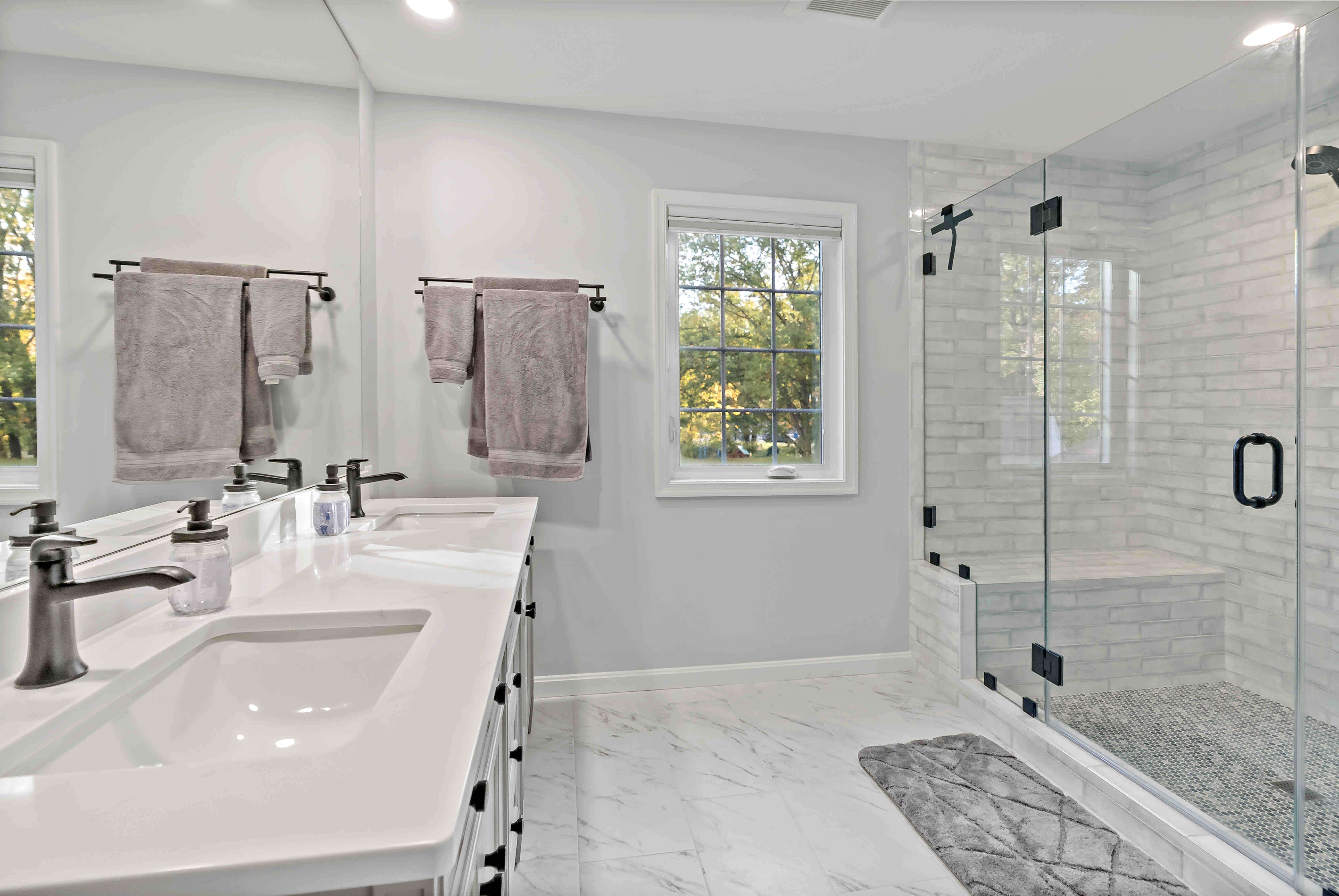 Large full bathroom with glass shower and bench