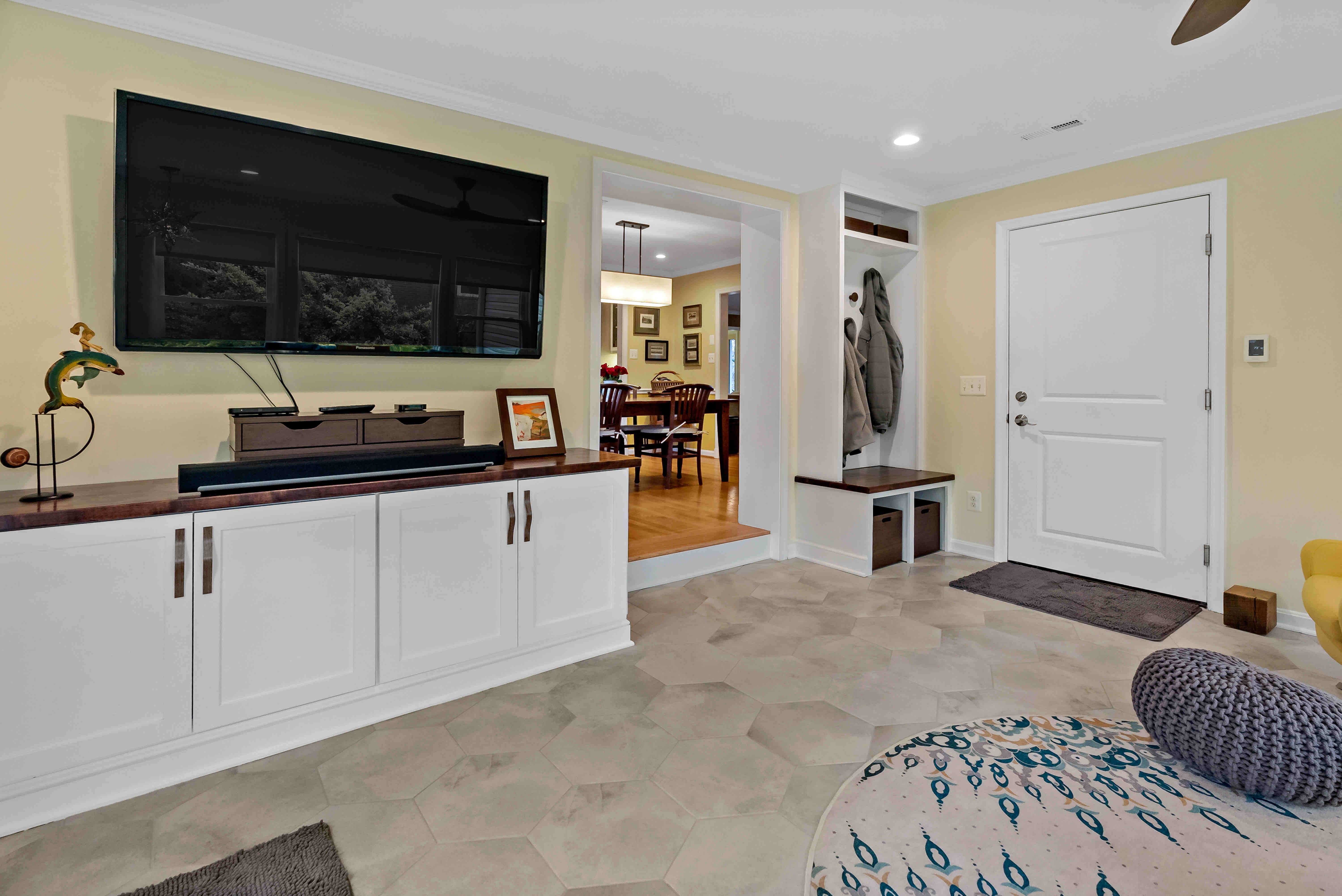 Carpeted TV room with white cabinets