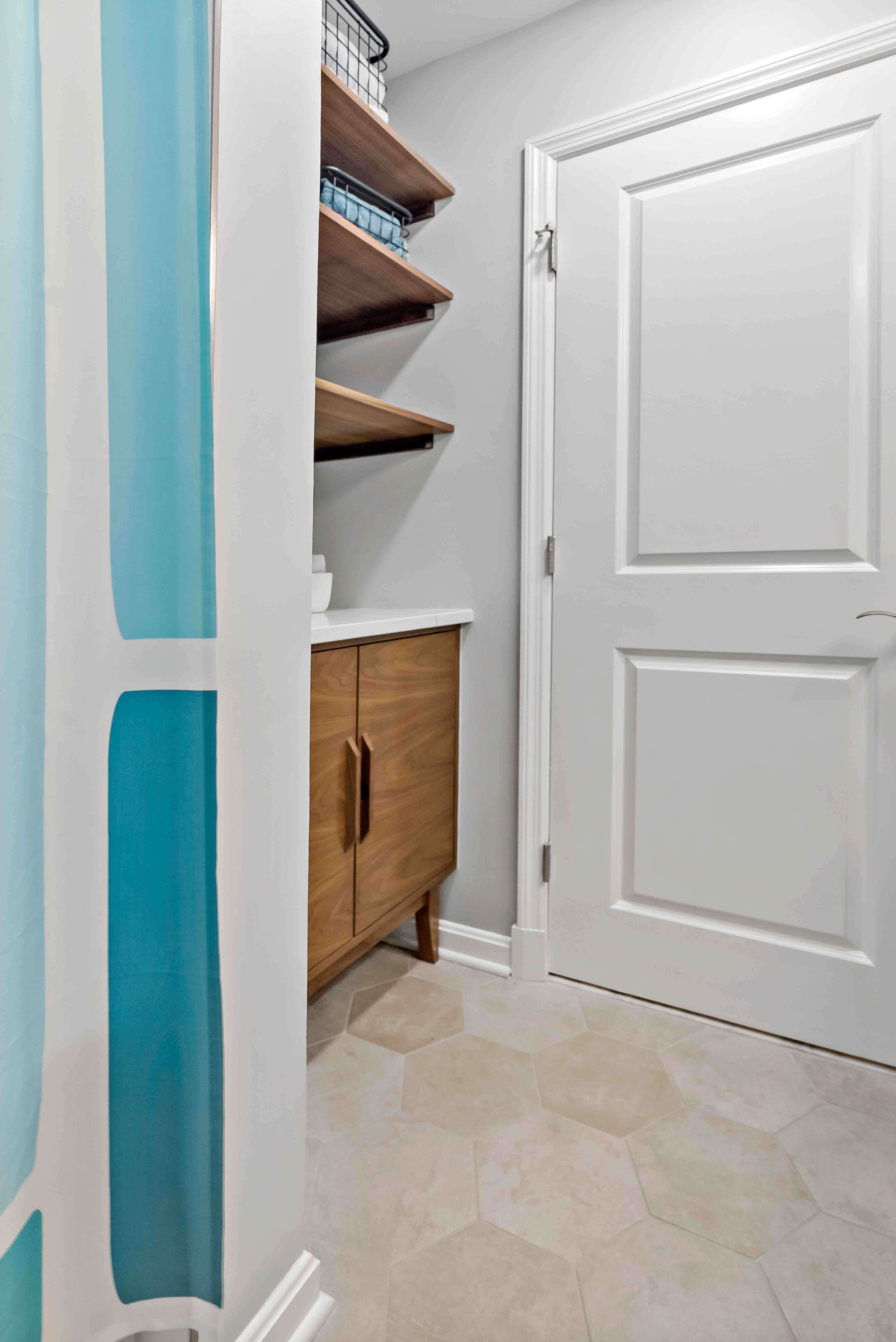 Built in wooden shelves behind door in bathroom