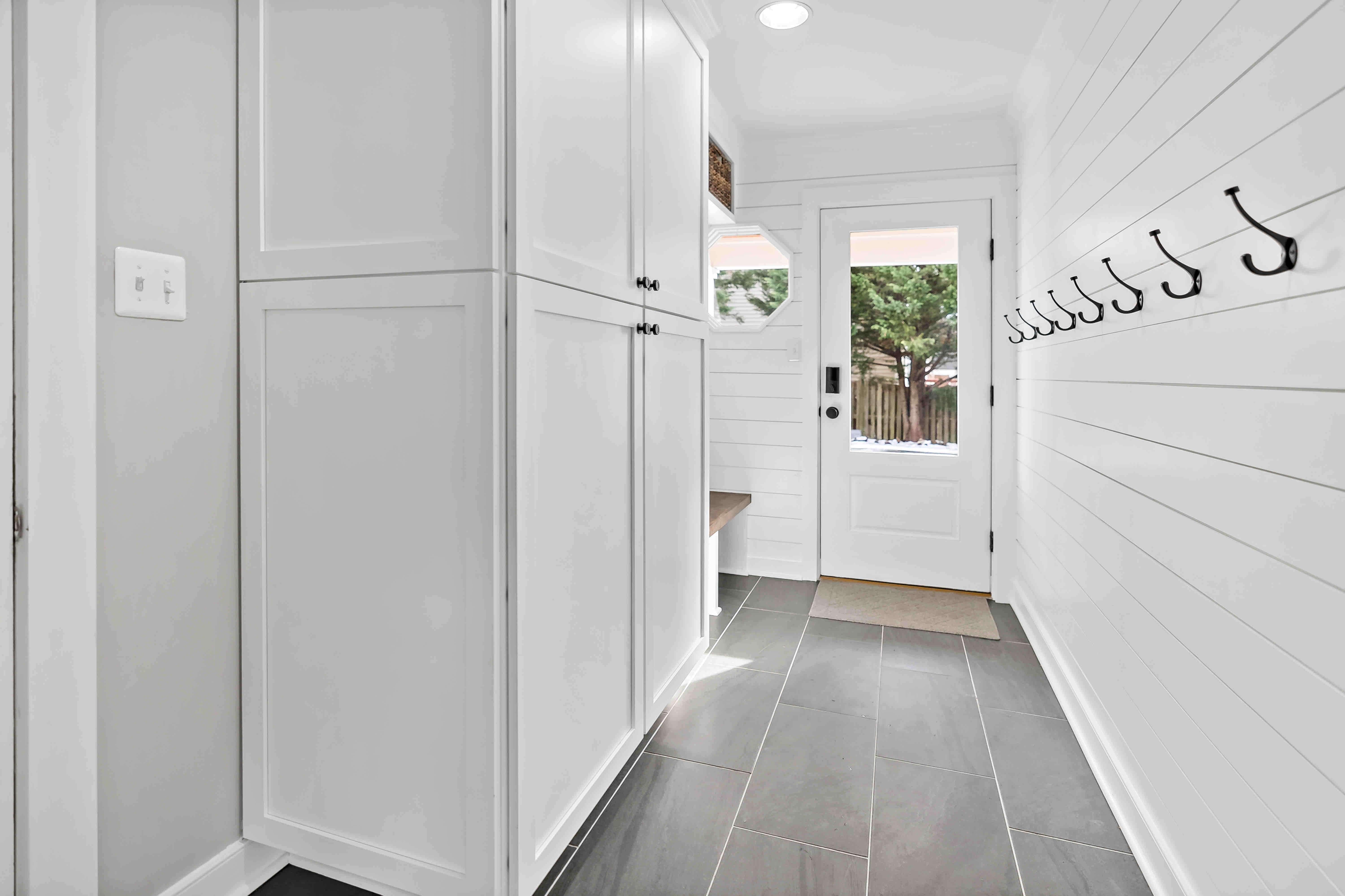 Mudroom at entrance of house with dark grey tile
