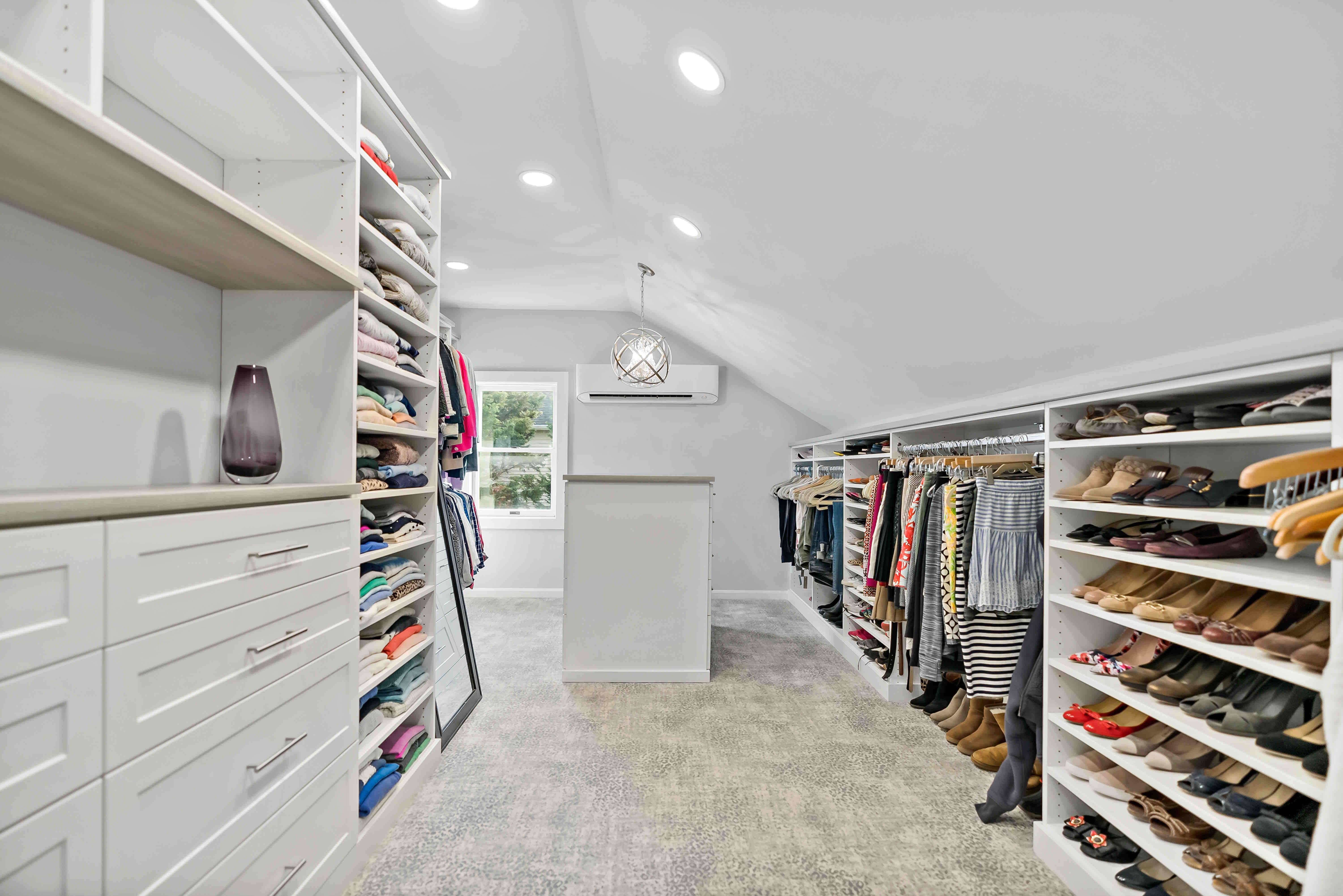 Large bedroom closet with multiple shelves for clothes