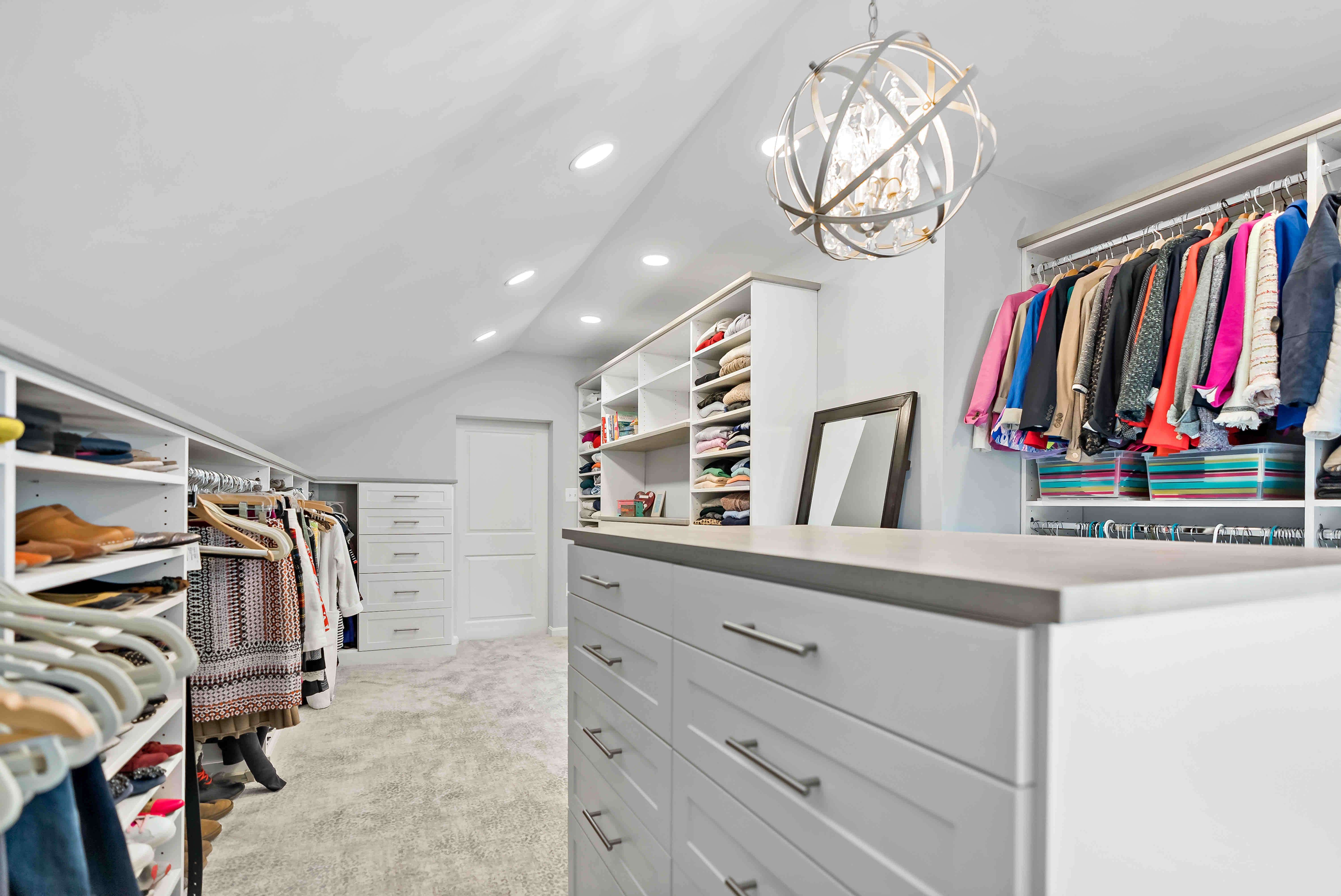 White walk in closet with chandelier