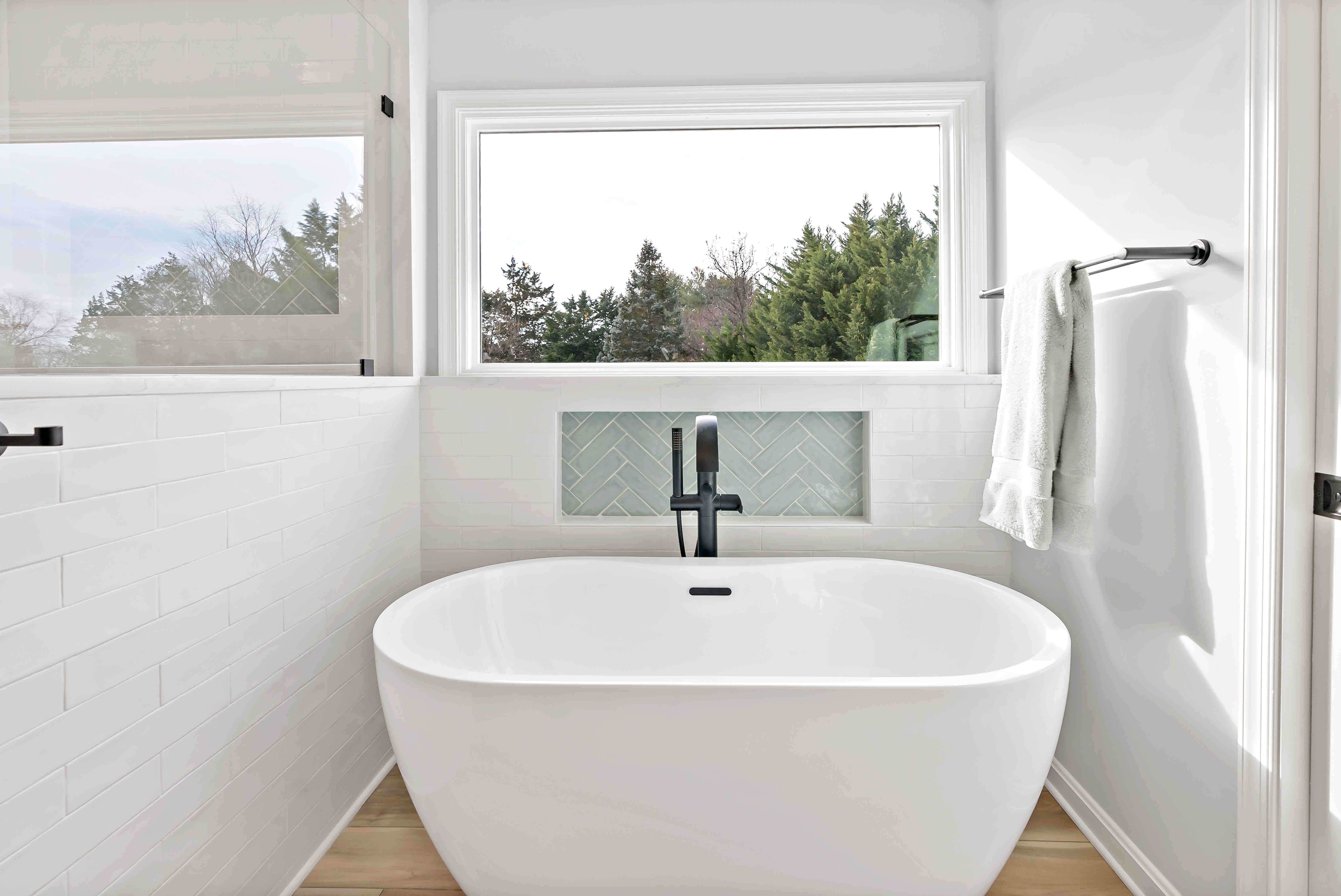 White stand-alone bathtub with black faucet