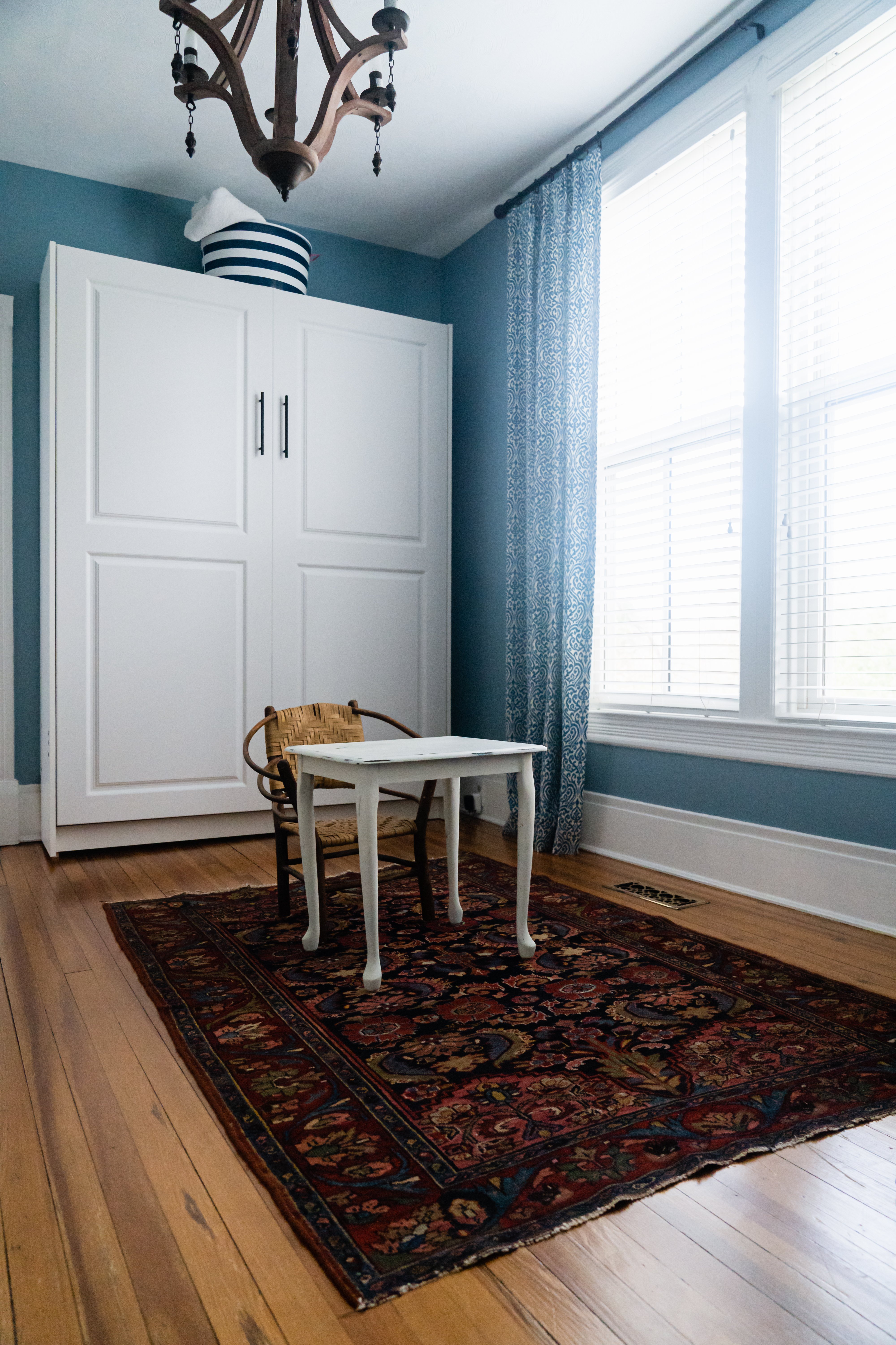 Open room with blue walls and white trim with hard wood floors