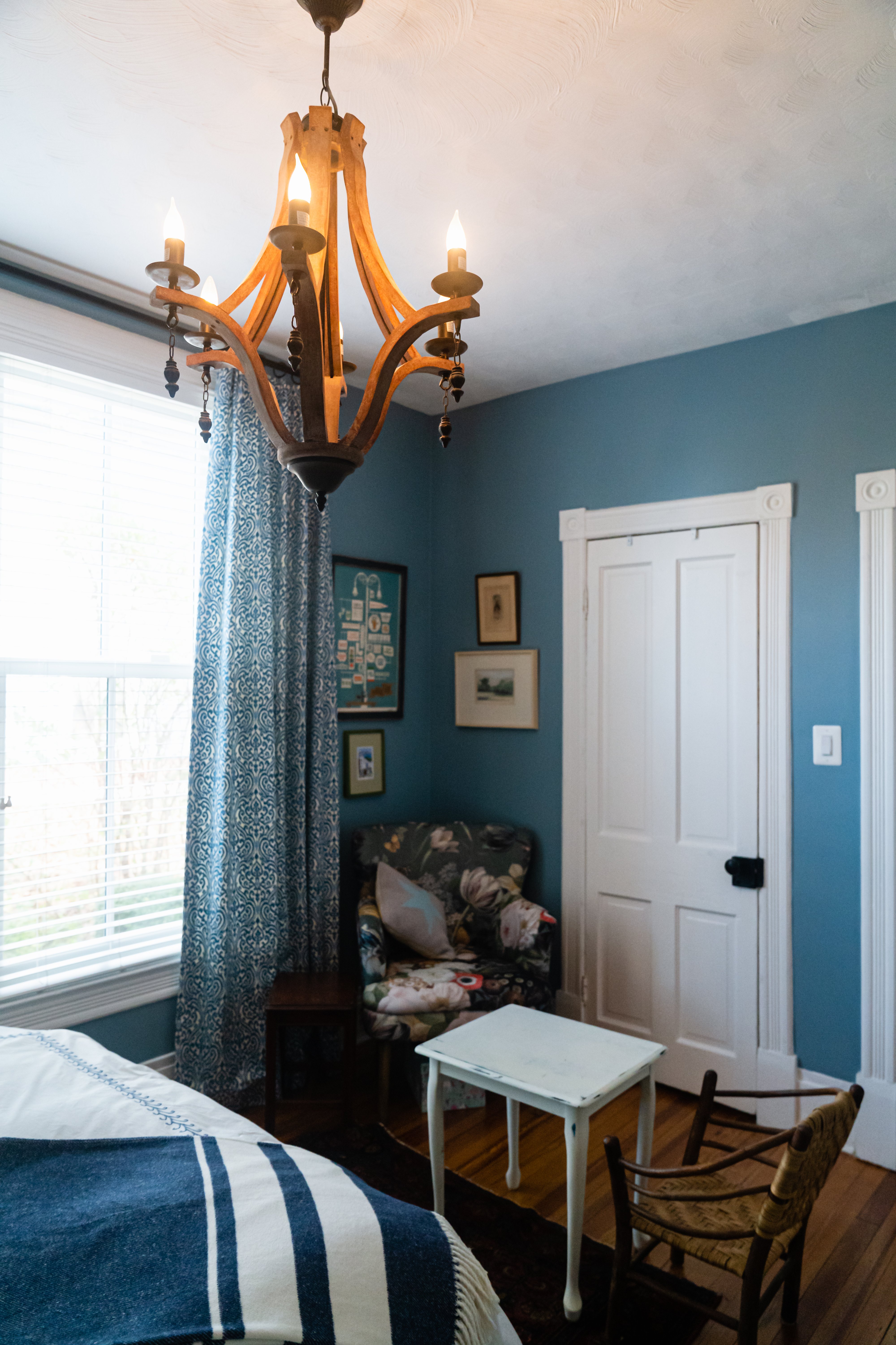 Dark blue walls in bedroom with chandelier