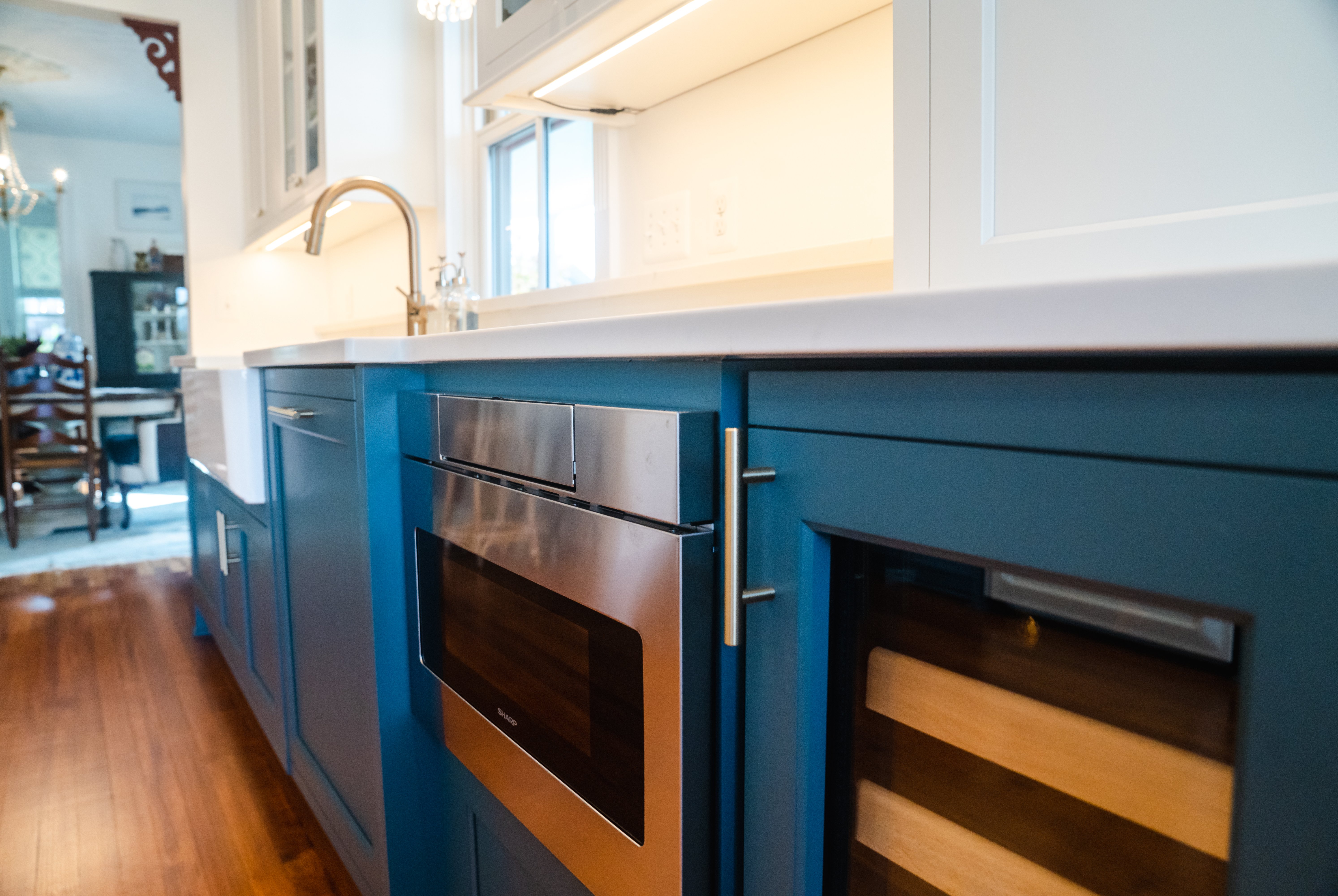 Dark blue with gold handles on cabinets in kitchen