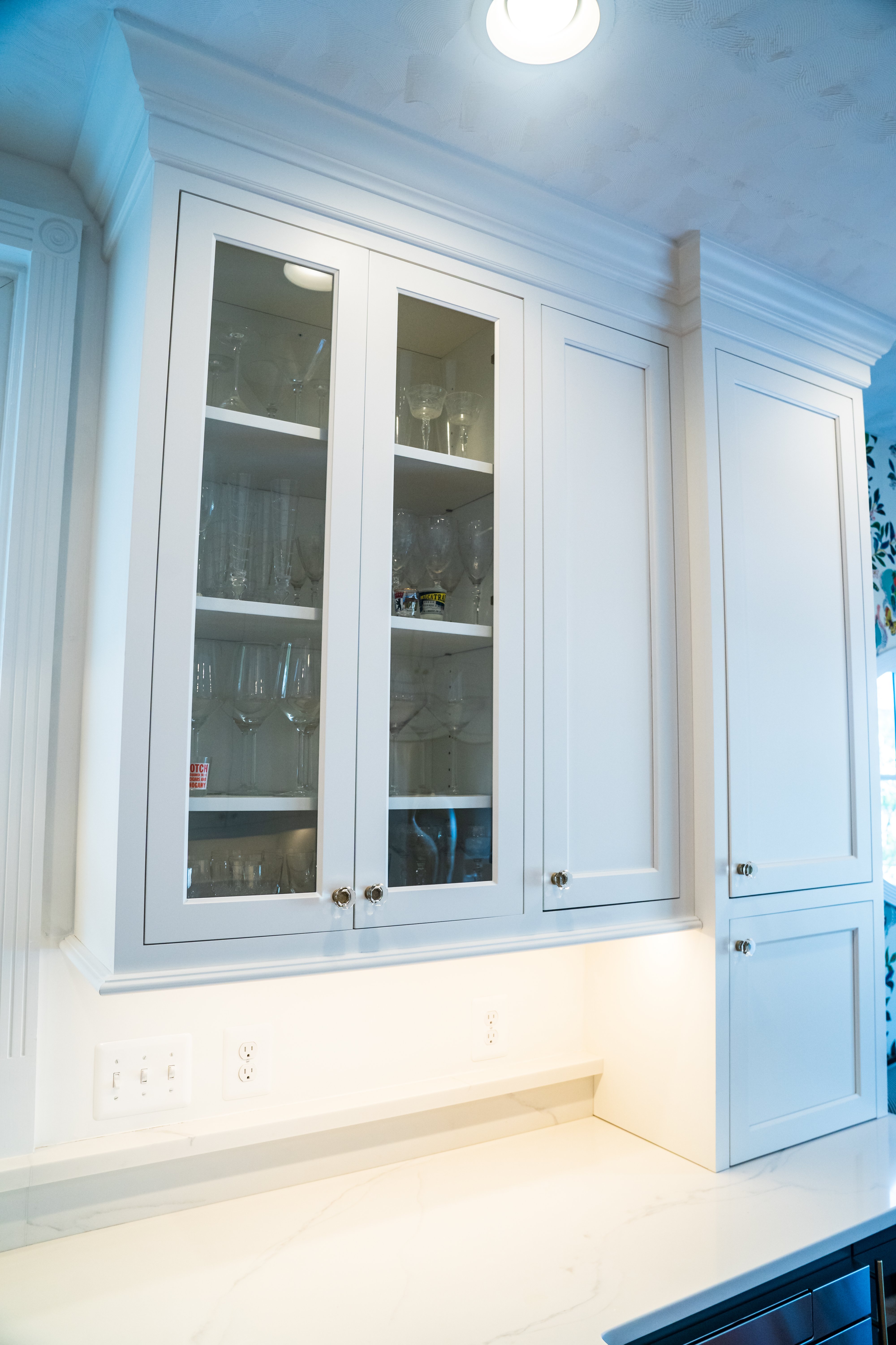 White cabinets with glass doors in kitchen