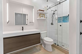 Full bathroom with walk-in shower and brown cabinets