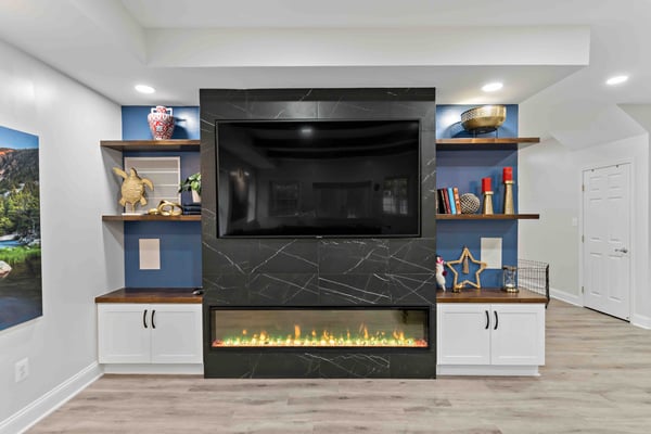 Built-in floating shelves and cabinets around mounted TV