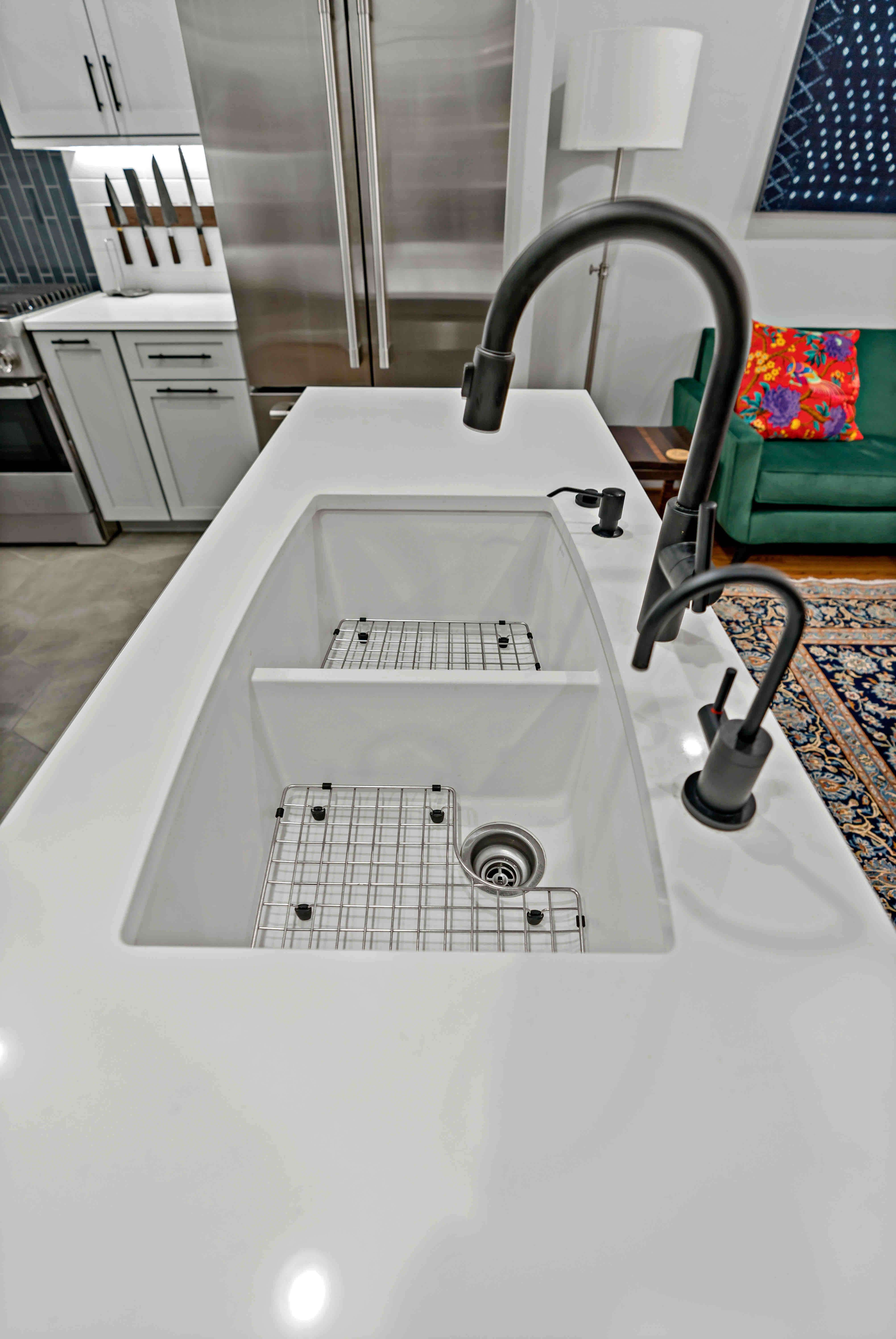 Kitchen sink in island with double bowl and black faucet