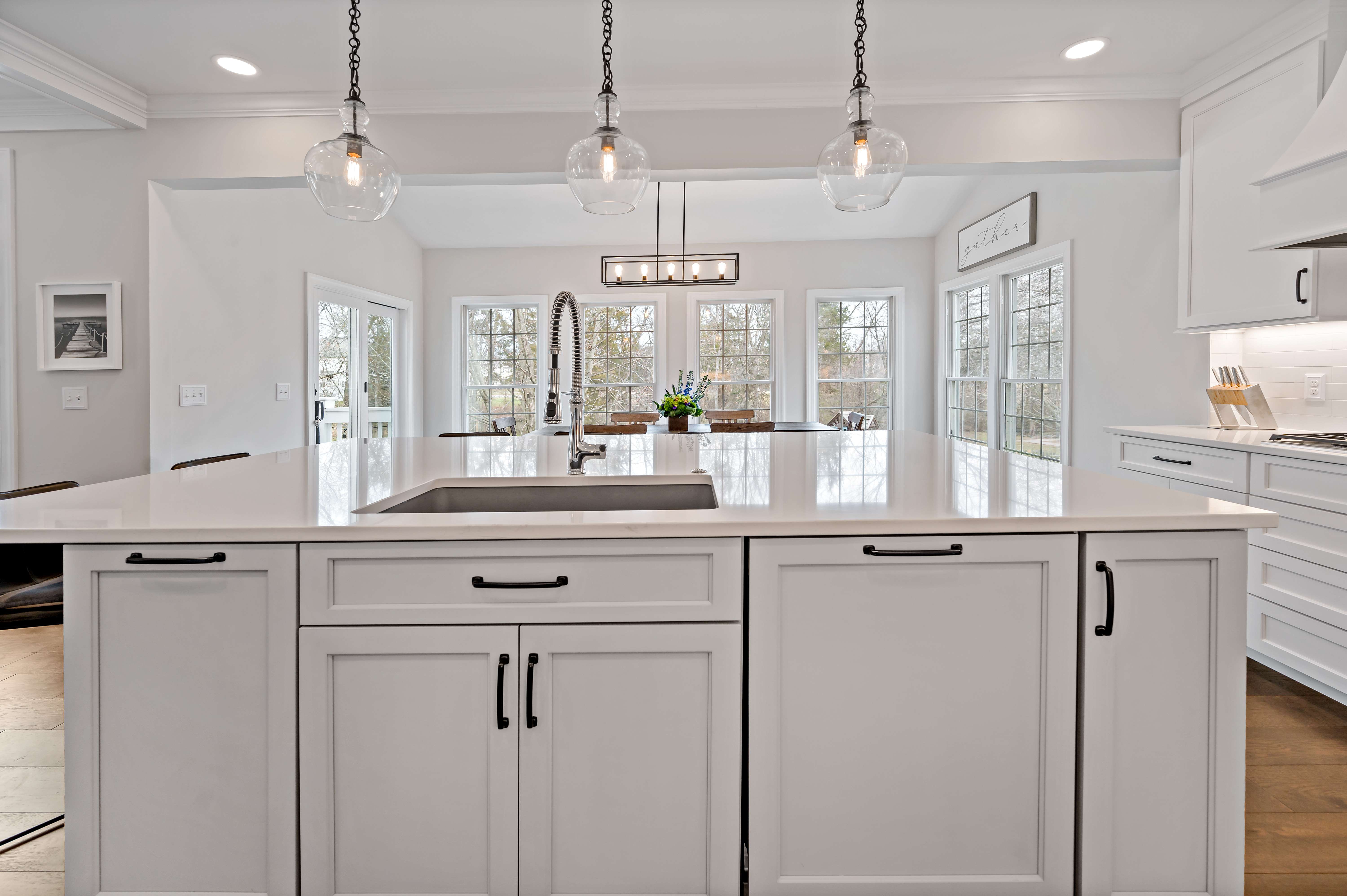 White kitchen island with sink and brass fixtures