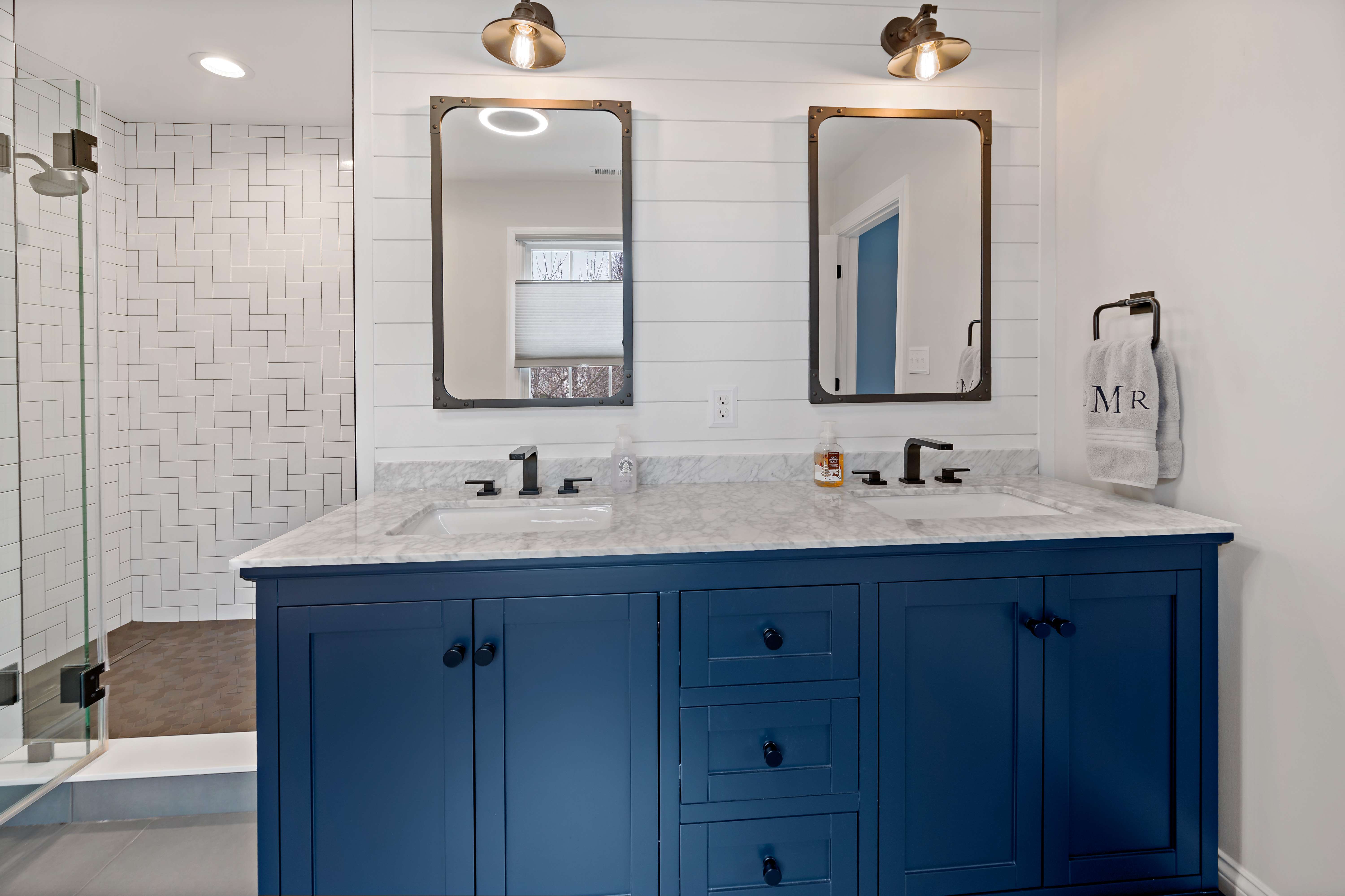 Double vanity and sink with dark blue cabinets in bathroom