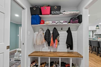 Mudroom with pocket doors and hooks and shelves