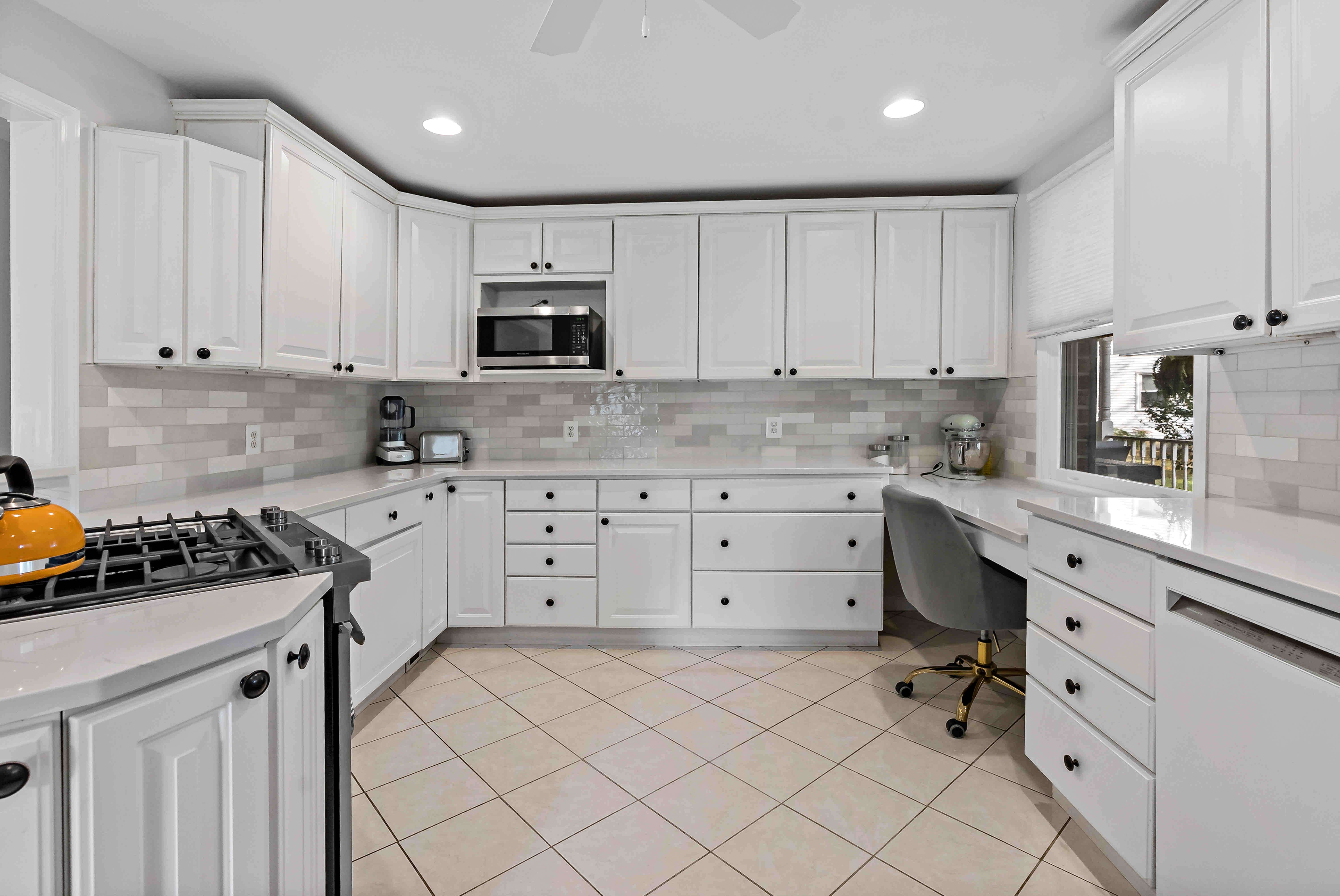 White cabinets and beige floor tiles in kitchen