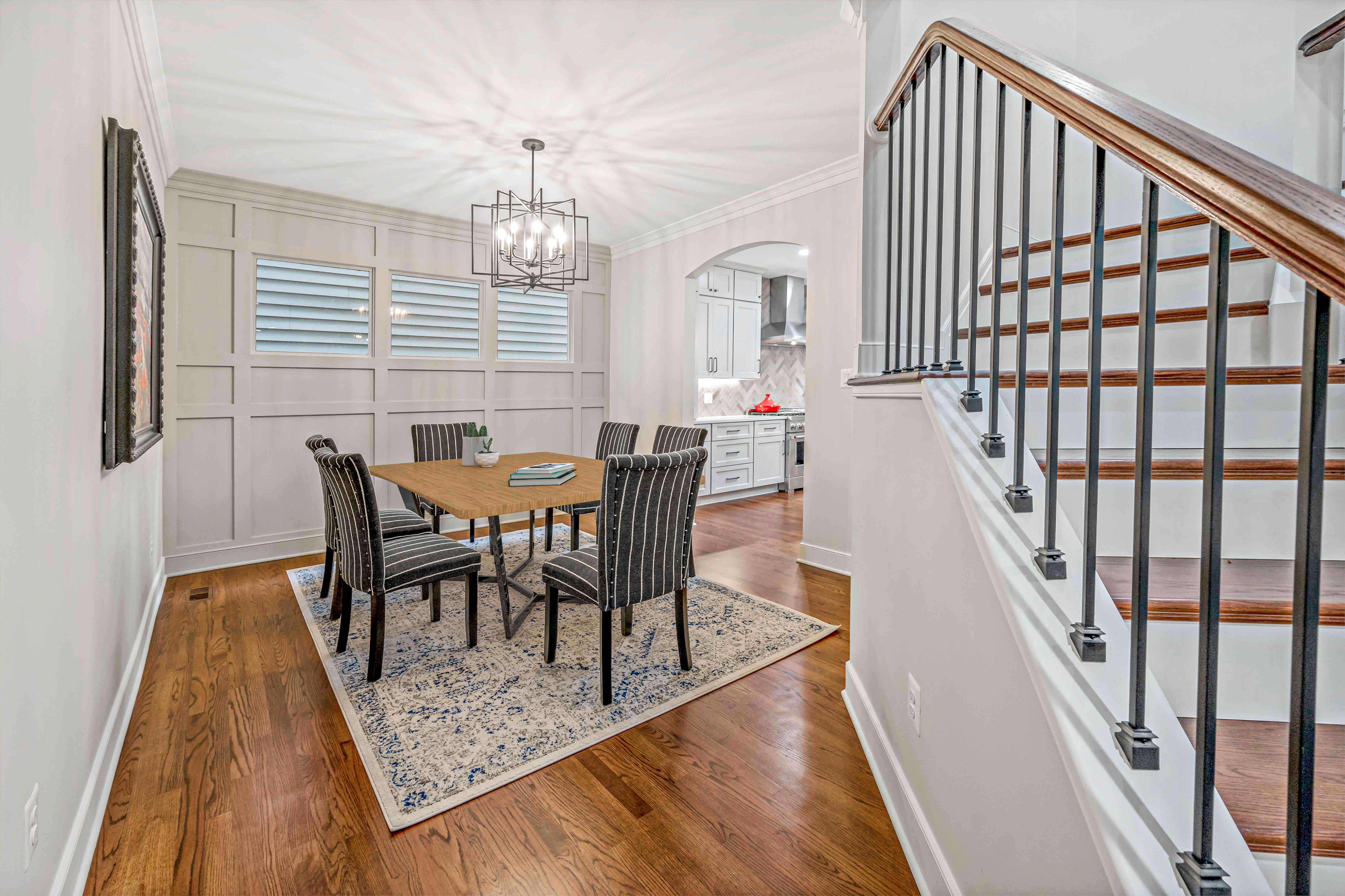Dining room table with curved stairs going upstairs