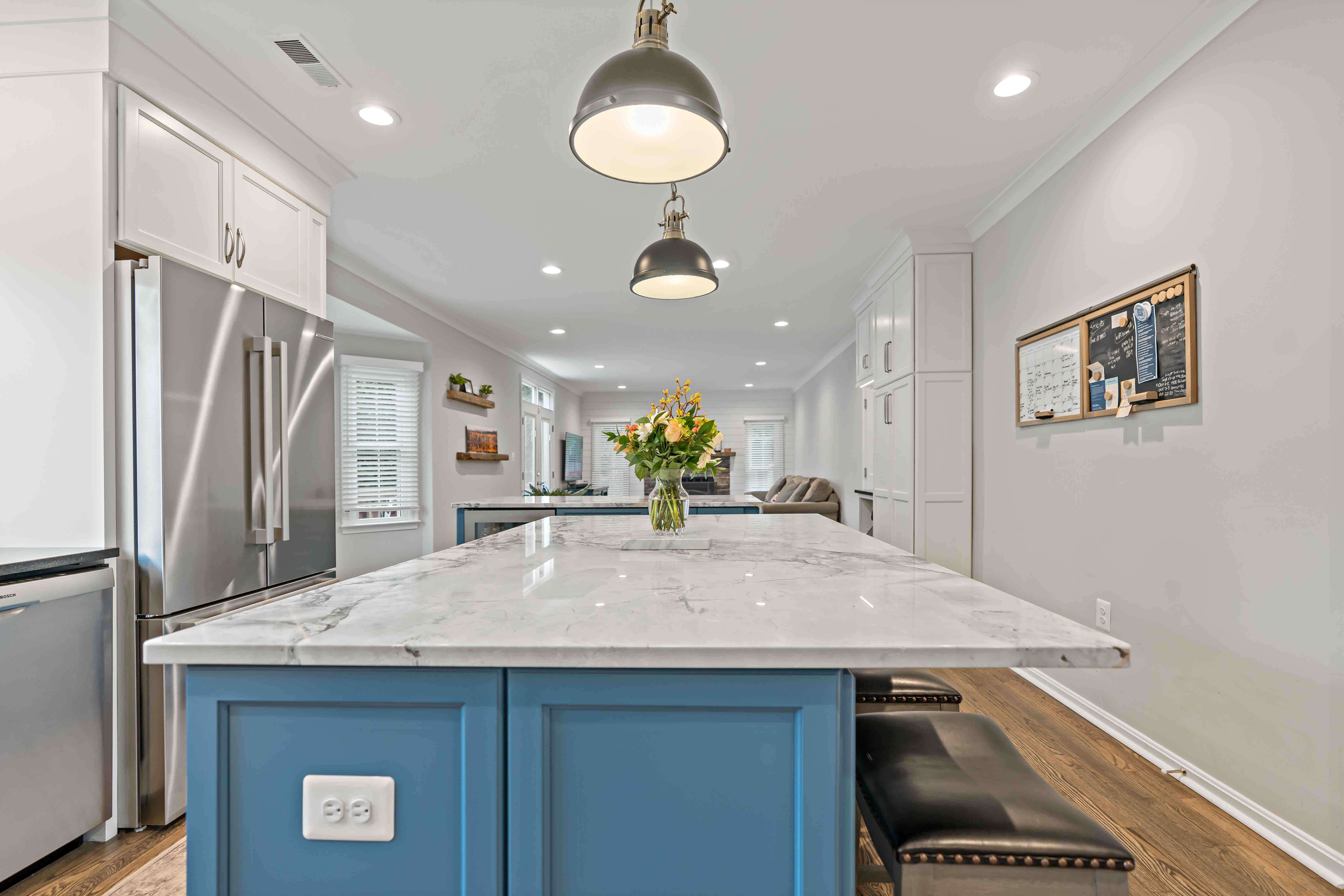 White kitchen with blue accent on kitchen islands and hard wood floors