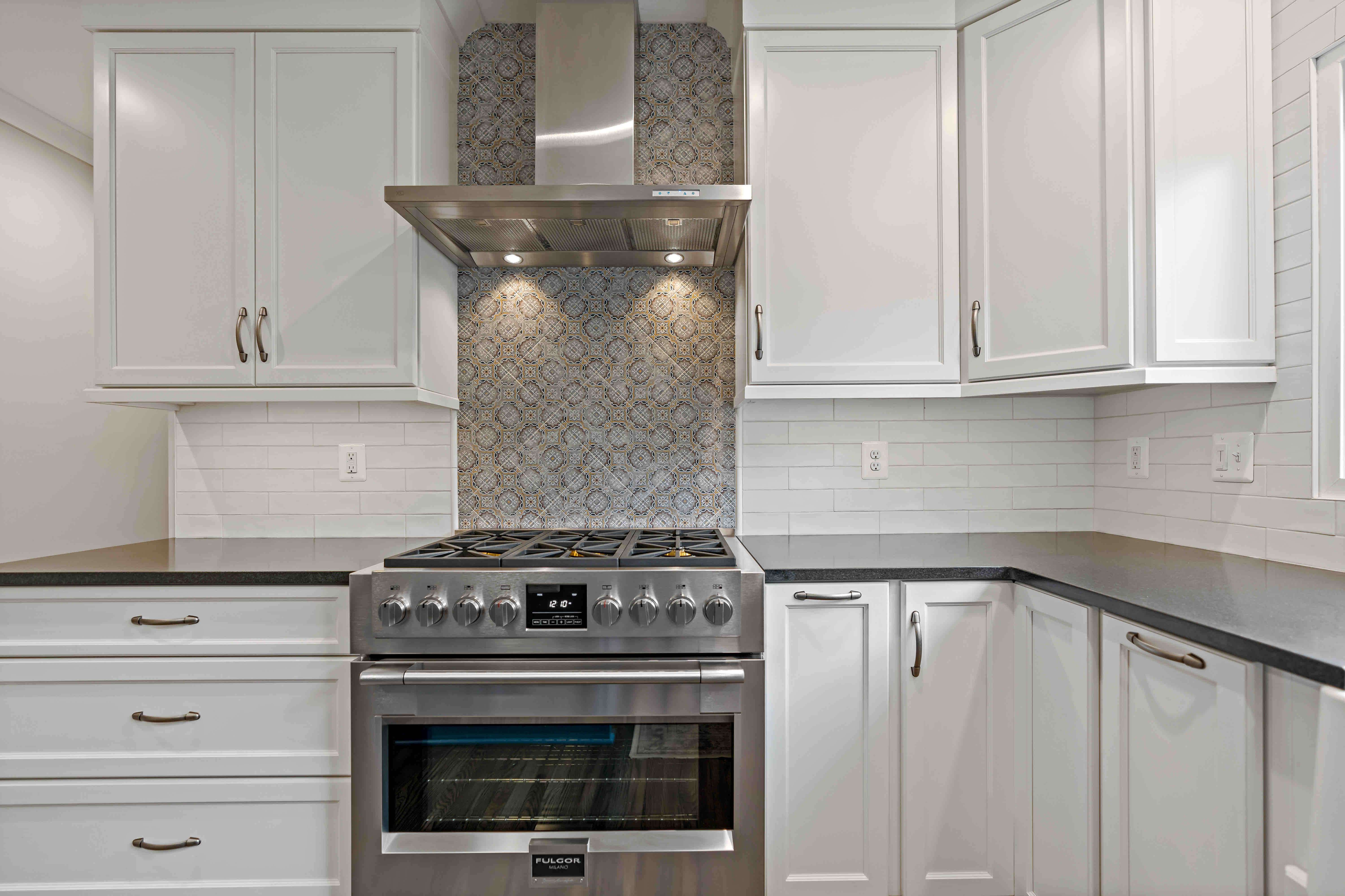 Grey backsplash accent behind stove top in kitchen
