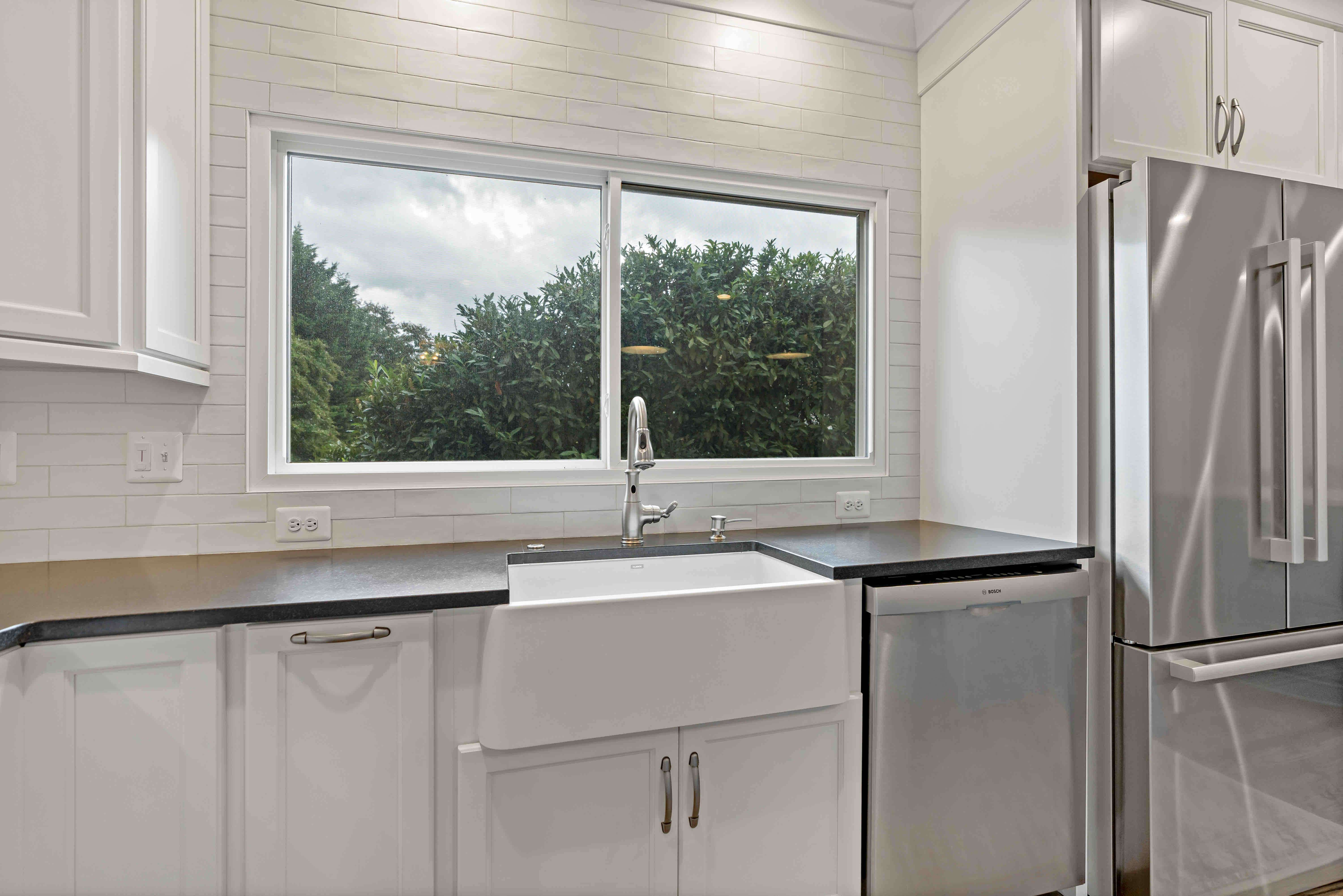 White cabinets and backsplash with dark brown countertops
